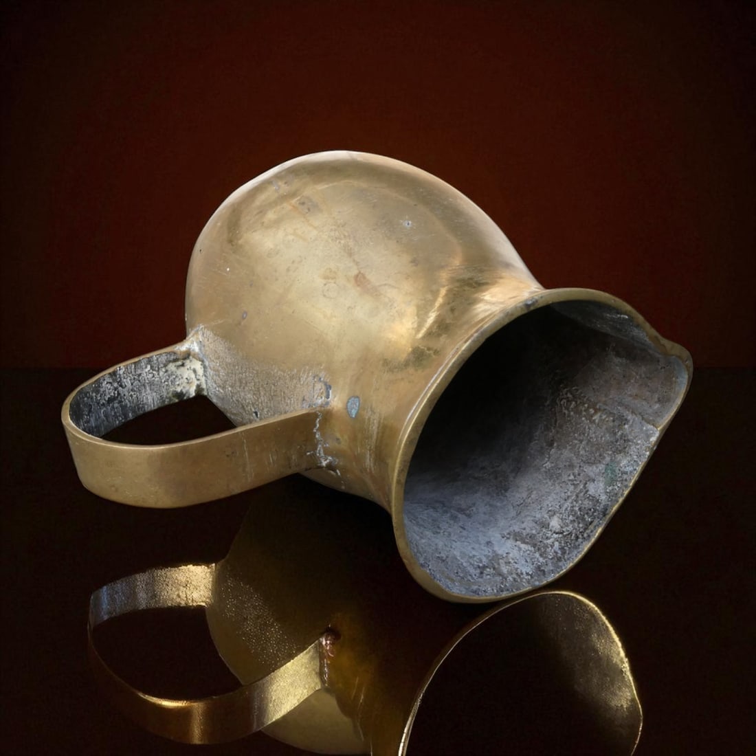 Antique Chinese Brass Ewer with Flared Spout and Handle, c. 1900s: This early 20th century Chinese brass jug features a baluster-shaped body with a pronounced rounded belly tapering to a narrow foot and flared spout, complemented by a substantial side handle. Weighin