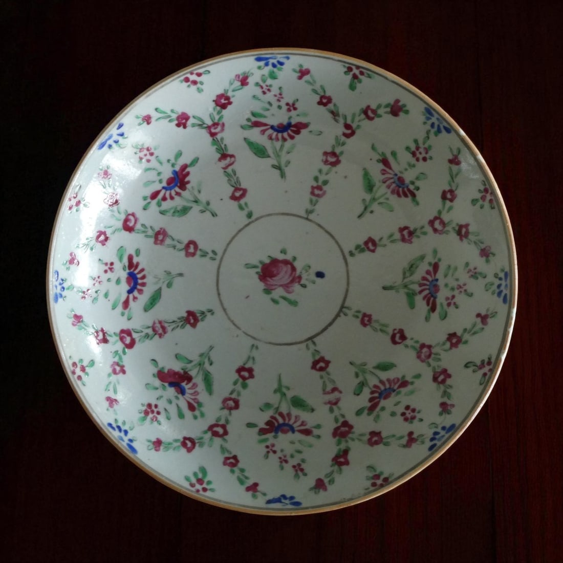 Qing Dynasty Famille Rose Porcelain Bowl with Floral Garlands, ca. 18th Century: This finely potted porcelain bowl, dating to the 18th century Qing dynasty, exemplifies the elegance and technical finesse of Chinese export wares produced for the European market. Measuring 25 cm in