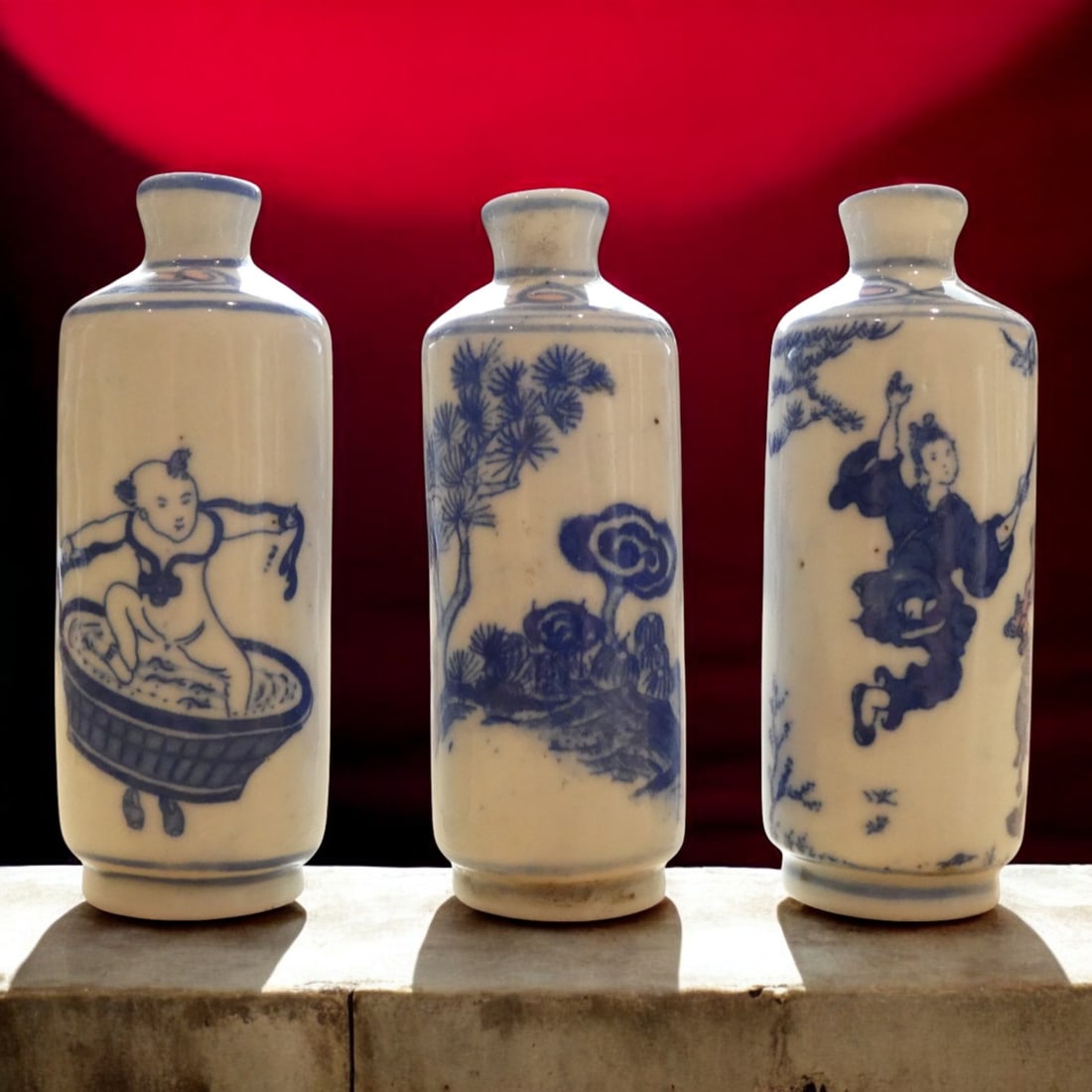 Set of Three Blue and White Porcelain Snuff Bottles, Tongzhi Period, c. 1862–1874: A charming and rare set of three cylindrical blue and white porcelain snuff bottles, each standing approximately 8 cm high, produced in China during the Tongzhi period (circa 1862–1874), Qing dynast