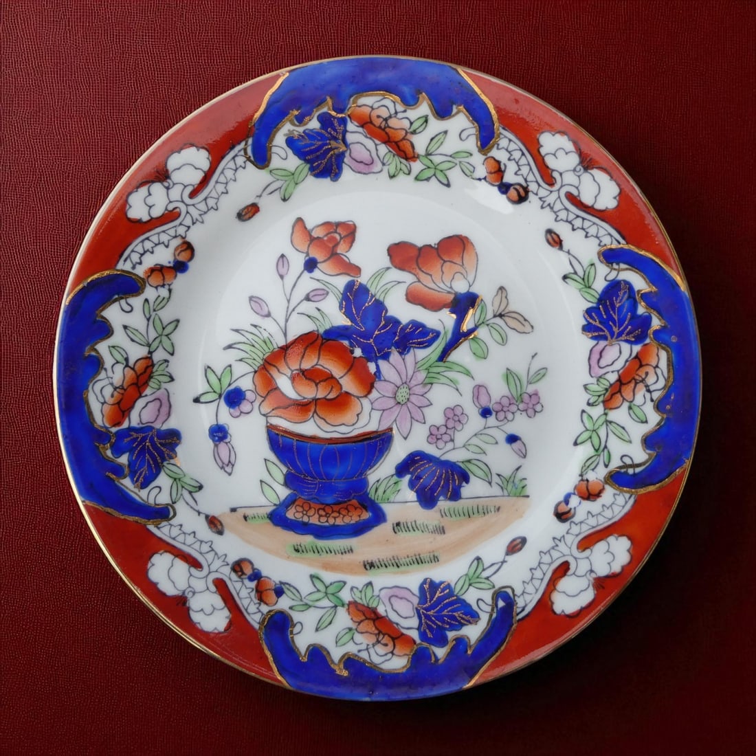 Colonial Macao Imari Porcelain Plate with Gilt Detail, c. 1950: A finely painted mid-20th century export porcelain plate from colonial Macao, measuring 15 cm in diameter and rendered in vibrant Imari palette of cobalt blue, iron red, green and gold. This decorativ