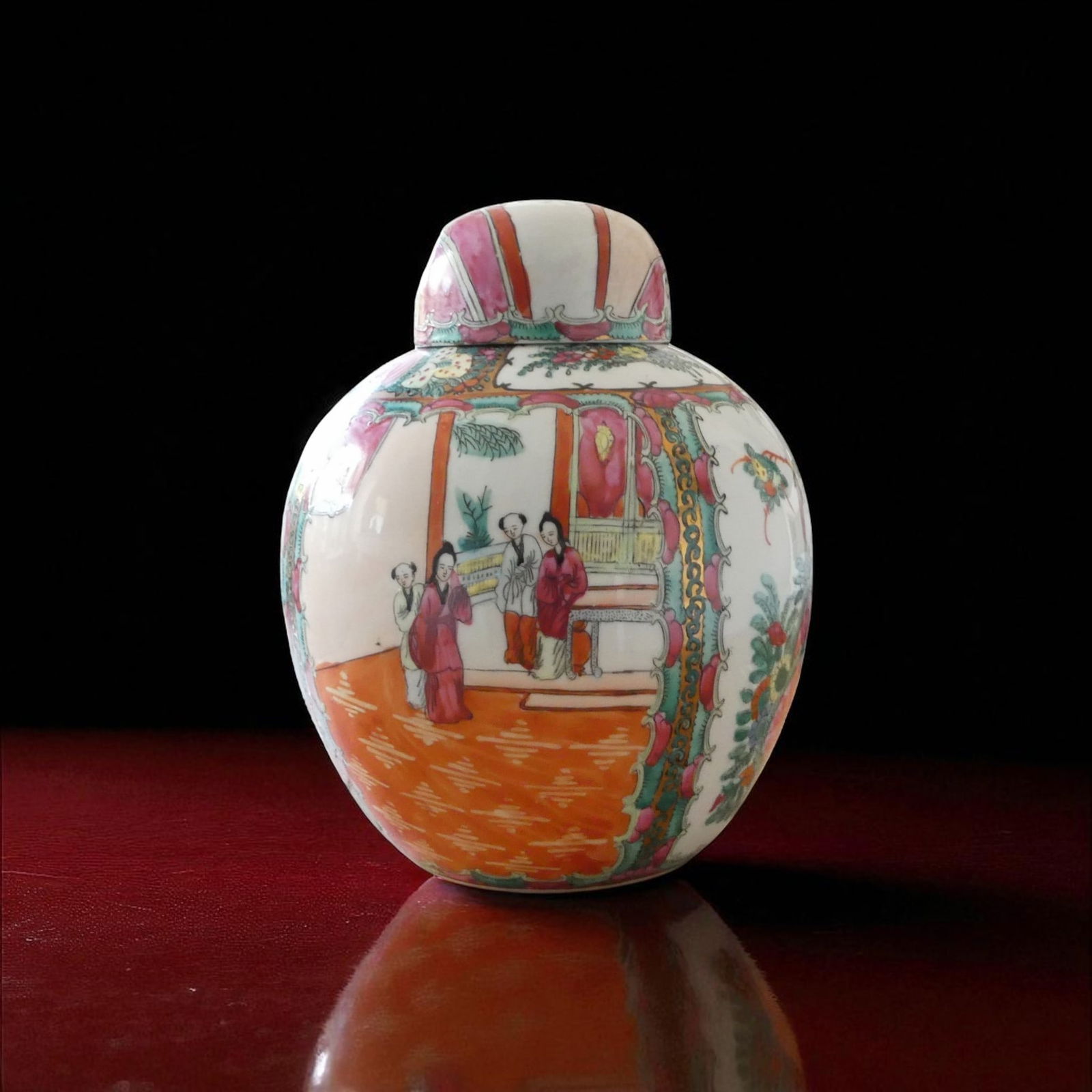 Famille Rose Covered Porcelain Jar with Court Scene, China, ca. 1950: This elegant famille rose porcelain covered jar, dating to circa 1950, exemplifies the enduring popularity of Qing Dynasty decorative traditions well into the mid-20th century. Standing 27 cm high wit