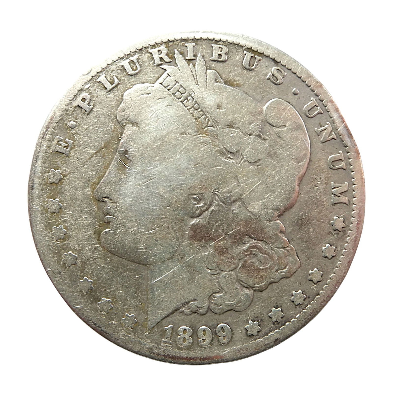 1899-O Morgan Silver Dollar, Liberty Head, Eagle Reverse: This is a circulated example of the 1899-O Morgan Silver Dollar, struck at the New Orleans Mint. The obverse features the classic Liberty head profile designed by George T. Morgan, surrounded by the L