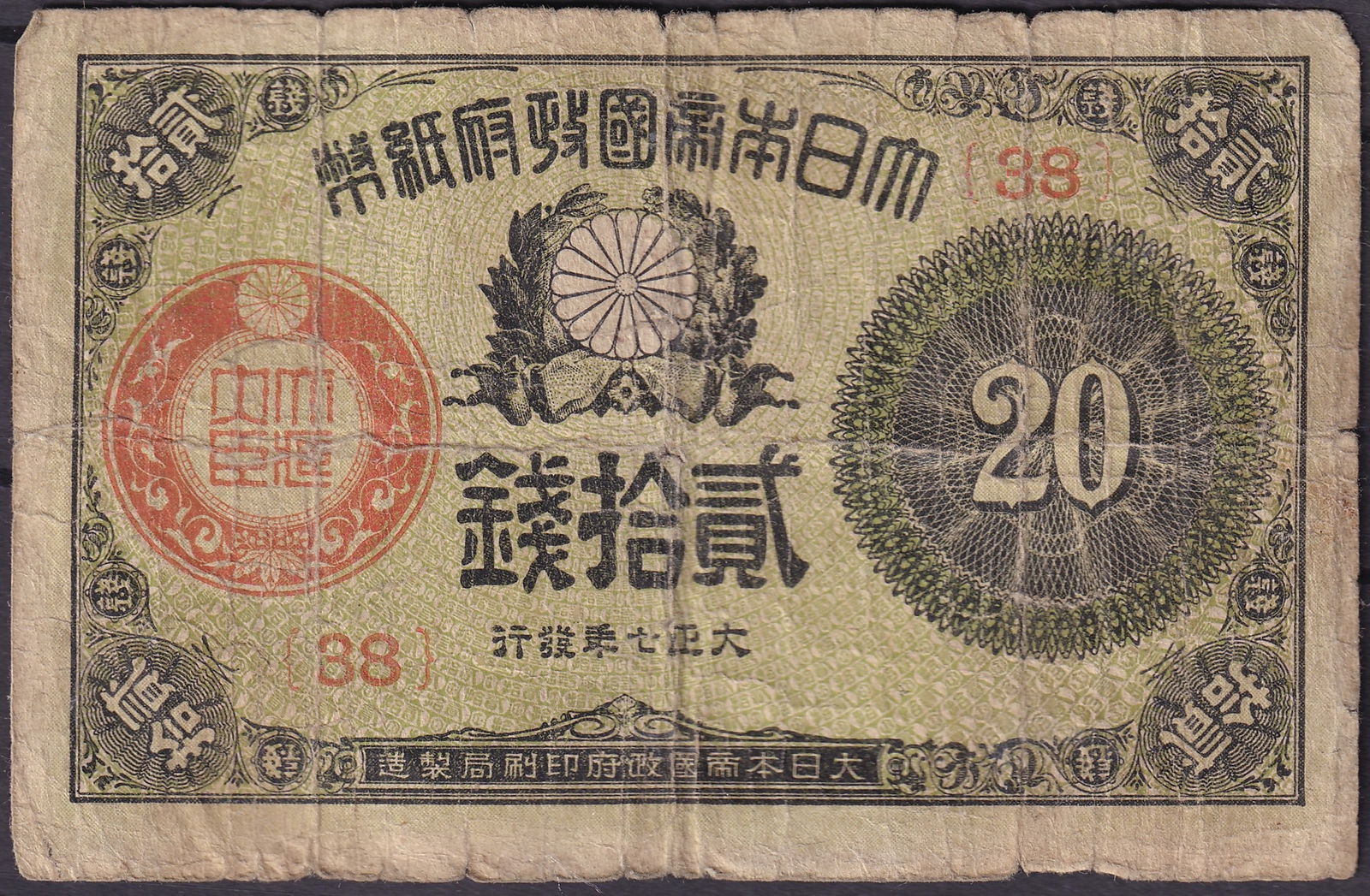 1918 Japan 20 Sen Note with Imperial Chrysanthemum Emblem, Taisho 7 Series 88 P-34: Issued in 1918 during the Taisho era, this 20 Sen banknote features the Imperial Chrysanthemum crest flanked by laurel branches and a large red seal of the Ministry of Finance. Printed in green and bl