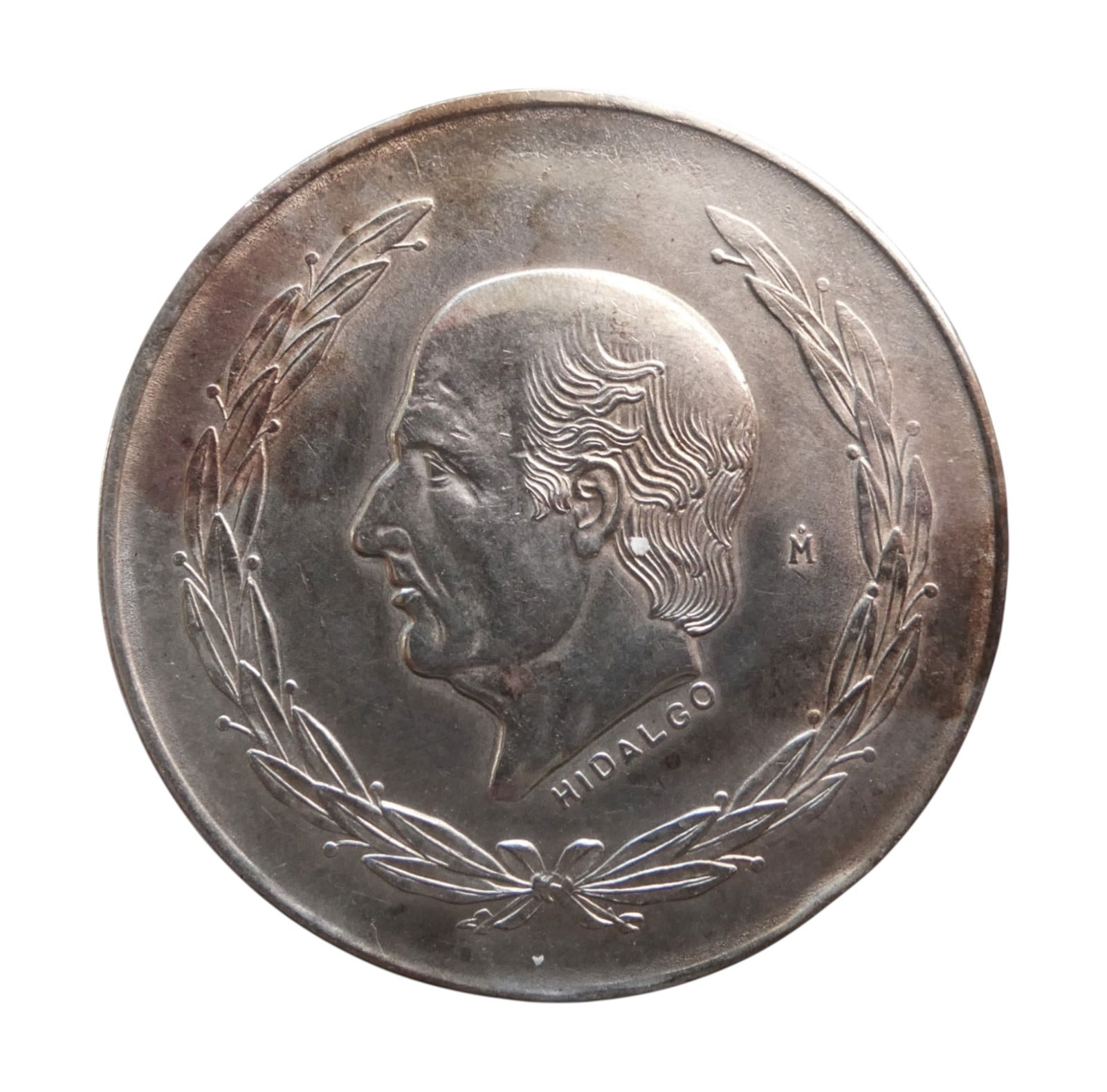 1953 Mexico 5 Pesos Silver Coin, Hidalgo Type, 0.720 Silver: This large 5 Pesos silver coin from Mexico, dated 1953, is part of the series issued between 1951 and 1954 during the era of the United Mexican States. The obverse features a strong-profile portrait o