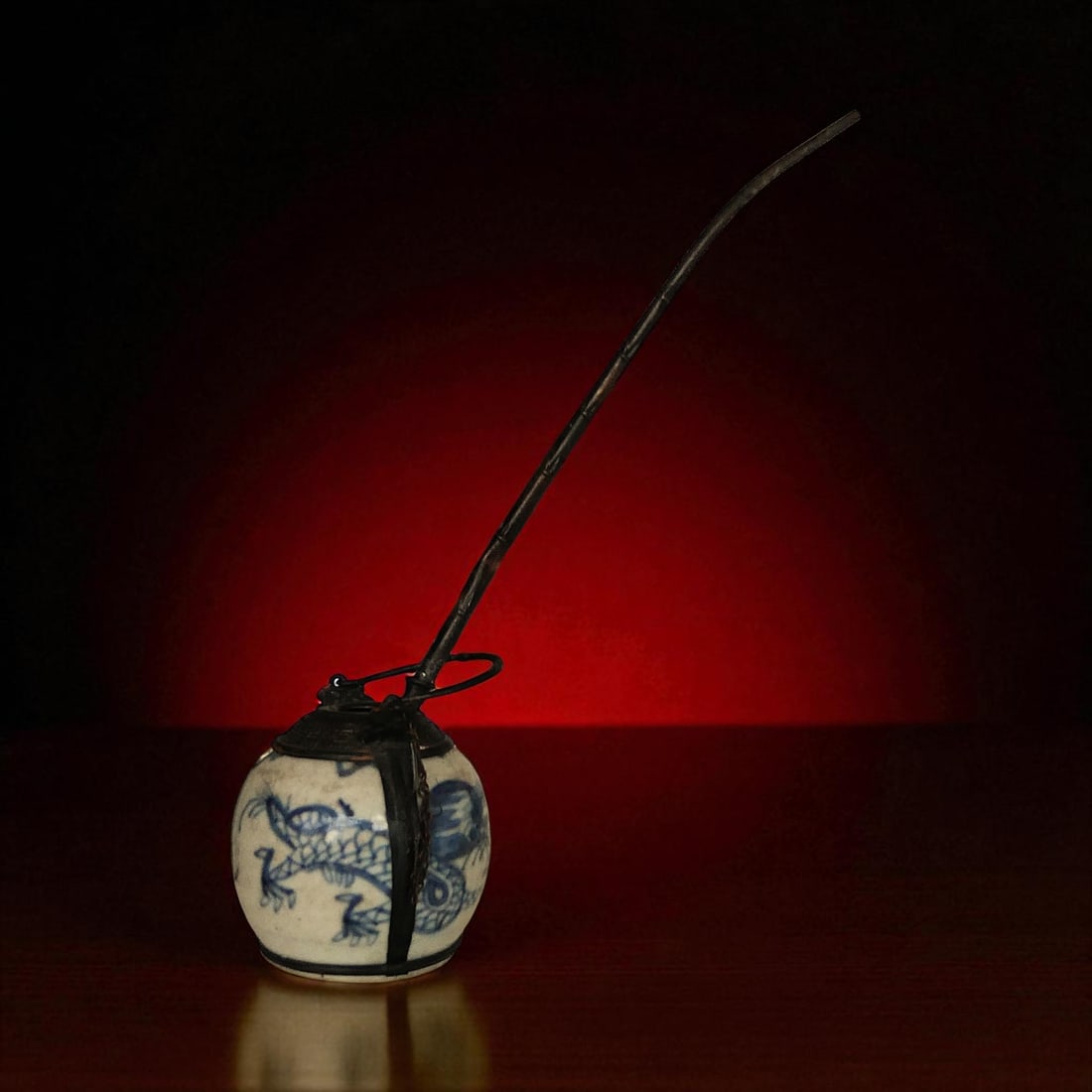 Chinese Qing Dynasty Blue and White Porcelain Opium Water Pot with Dragon, 19th Century: An original 19th century Qing Dynasty blue and white porcelain opium water pot of ovoid form, weighing 239 grams and standing 7 cm high, mounted with its original decorative metal fittings. The body i