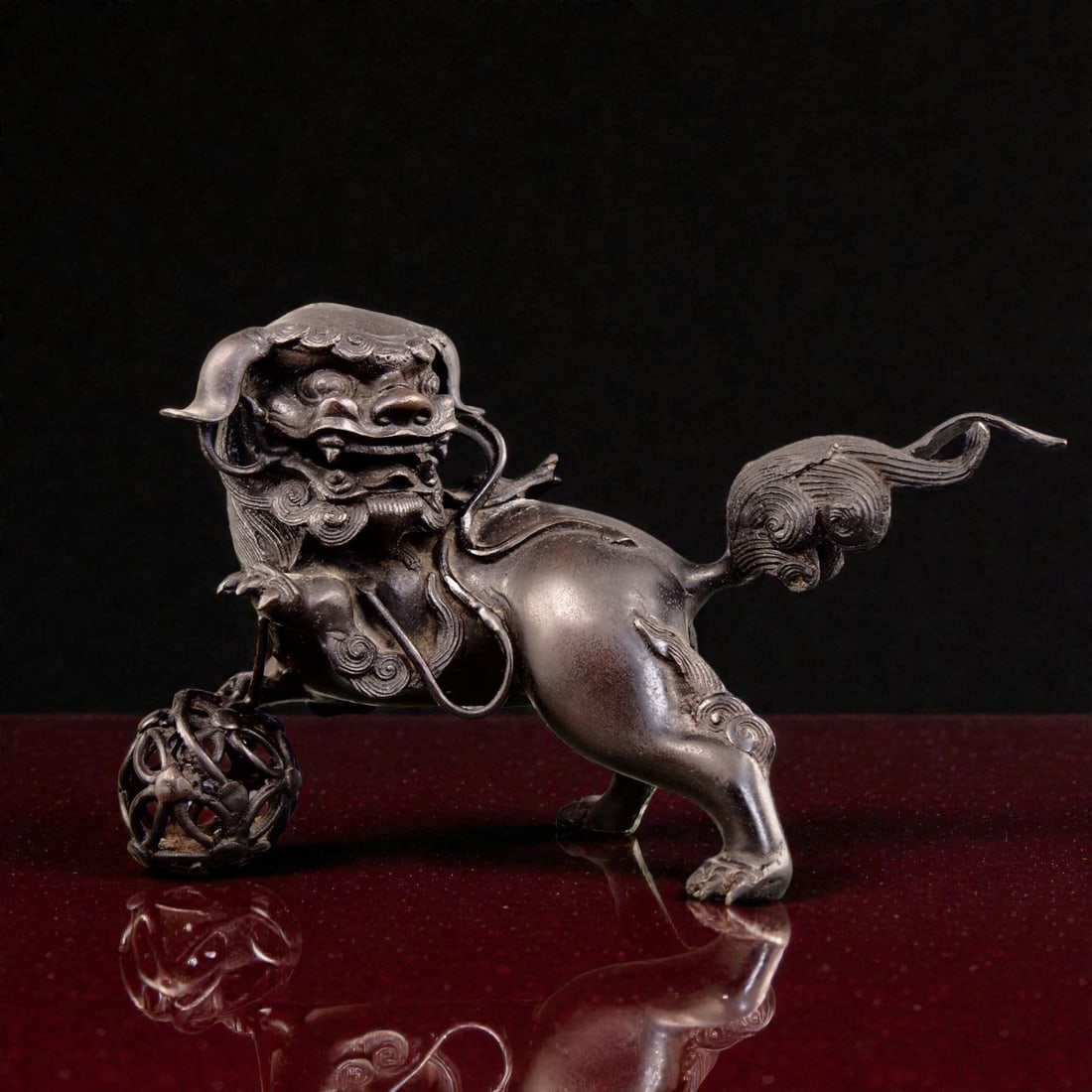 Meiji Period Japan Bronze Shishi Lion on Ball Guardian Sculpture: This impressive bronze tama nori shishi lion standing on a ball was made in Japan during the Meiji period and captures the dramatic power and protective symbolism associated with guardian lions in tra