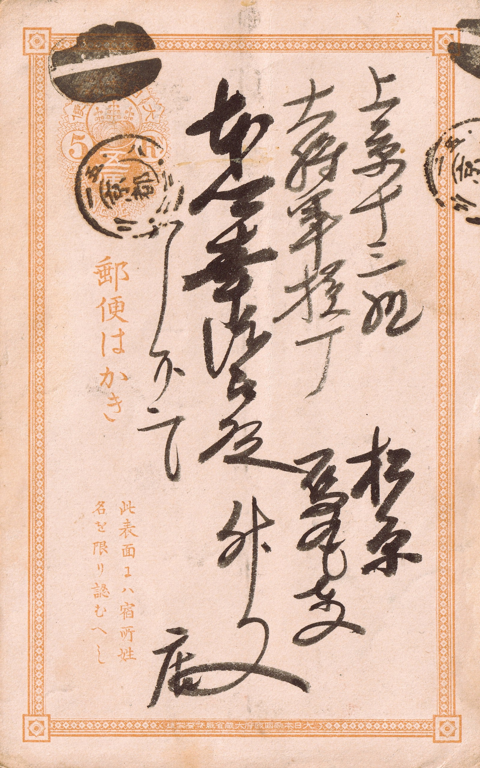 Prepaid Japanese Postal Card, 5 sen, Meiji Period: This striking Japanese postal card, issued during the later Meiji era, features a preprinted postage value of 5 sen, rendered in a rich reddish-orange hue. The design centers around an ornate circular