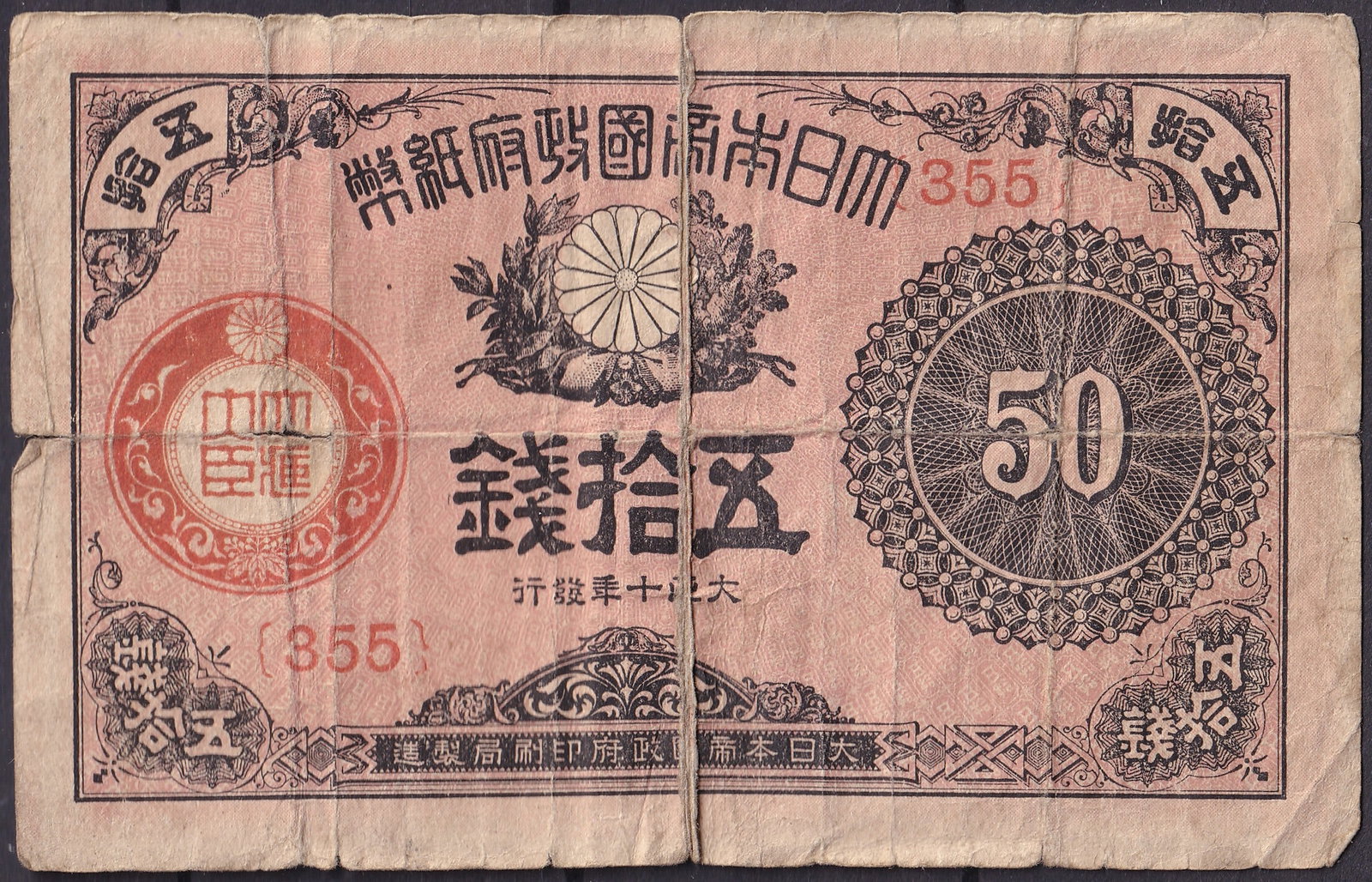 Japan 50 Sen Banknote 1882–1887 Chrysanthemum Crest P#23: Issued between 1882 and 1887 during the Meiji era, this 50 Sen note is one of the earliest fractional currency issues of modern Japan. Printed in black and red on thin paper, the obverse displays a bo