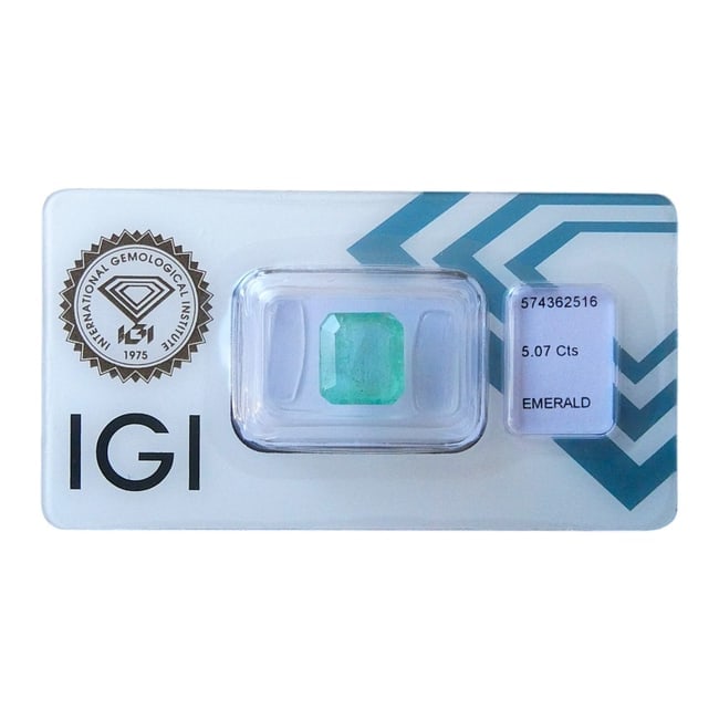 IGI Certified Natural Emerald - 5.07 ct, Bluish Green (Niger Origin): This is a certified natural emerald, weighing 5.07 carats, with a beautiful bluish-green hue. The stone is transparent with natural inclusions, which is typical for emeralds. It has been cut in an eme