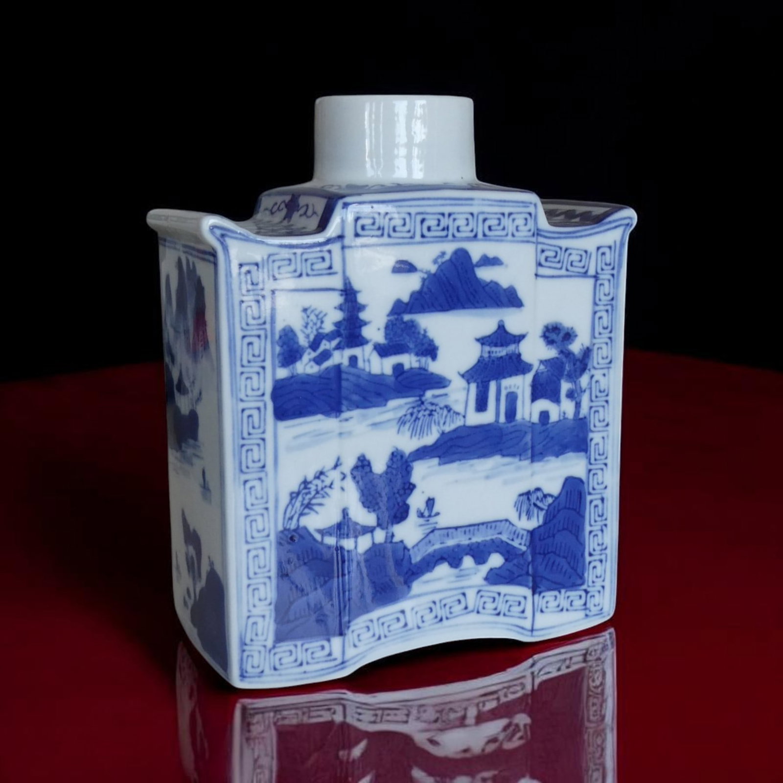 20th Century China Blue and White Porcelain Vase Landscape Scene: Chinese porcelain vase of distinctive and uncommon form, featuring a concave-sided square body with gently curved panels and a short cylindrical neck, executed in classic underglaze cobalt blue on a w