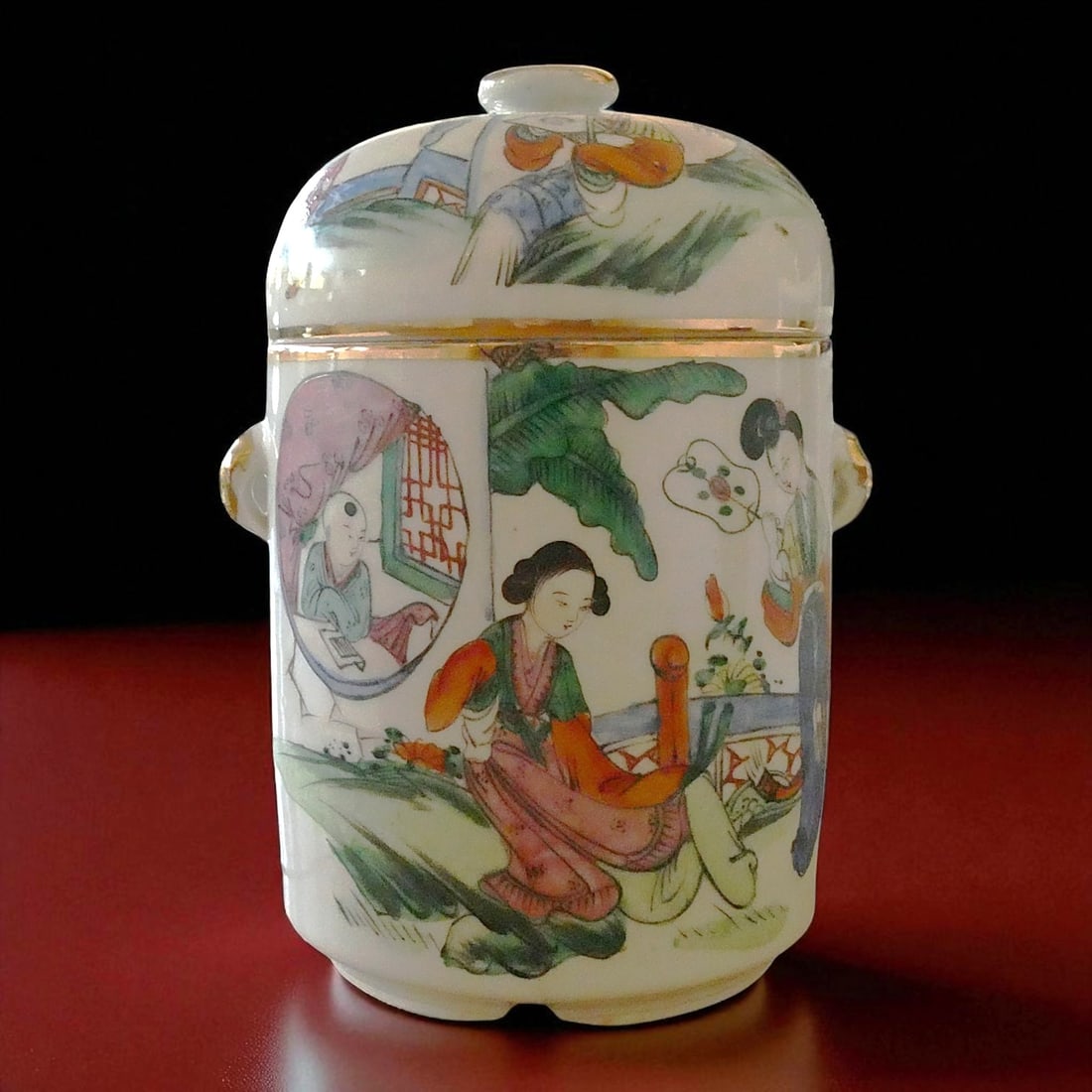 Famille Rose Porcelain Jar with Double Lids and Court Scene, China, c. 1900: This elegant famille rose porcelain jar, crafted in China around the turn of the 20th century (circa 1900), is a refined example of late Qing decorative porcelain combining figural narrative with poet