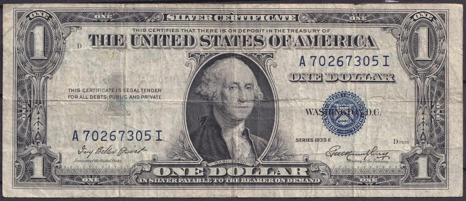 USA 1935E 1 Silver Certificate – Serial A70267305I: Offered here is a United States one-dollar silver certificate, Series 1935E, bearing the serial number A70267305I in blue ink. This historic note features the portrait of George Washington at center a