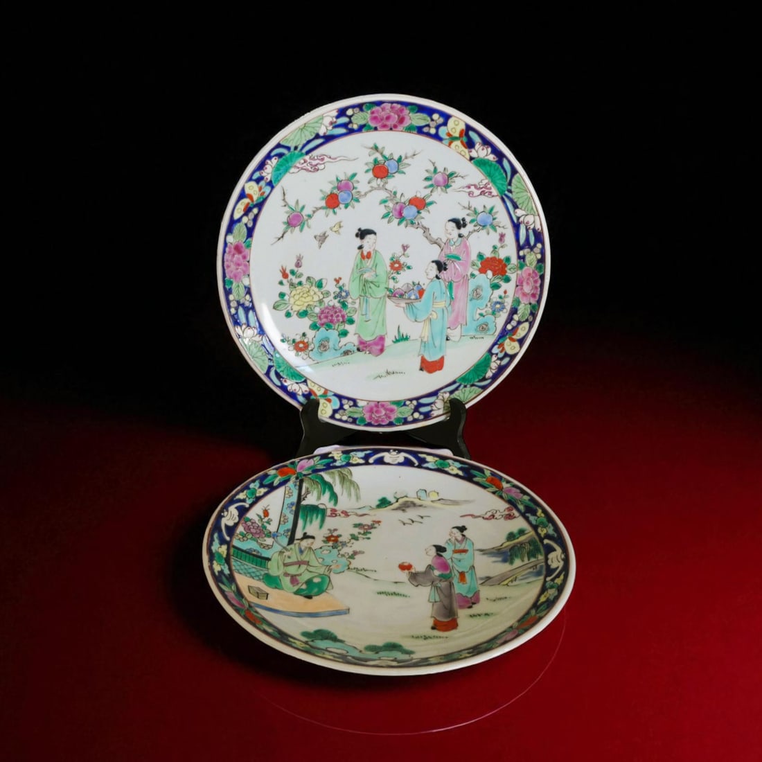 Pair of Chinese Famille Rose Plates with Courtly Figures, 19th Century: A fine pair of Chinese porcelain plates, dating to the 19th century, each delicately decorated in famille rose enamels with richly detailed scenes of courtly figures amidst garden landscapes. One plat