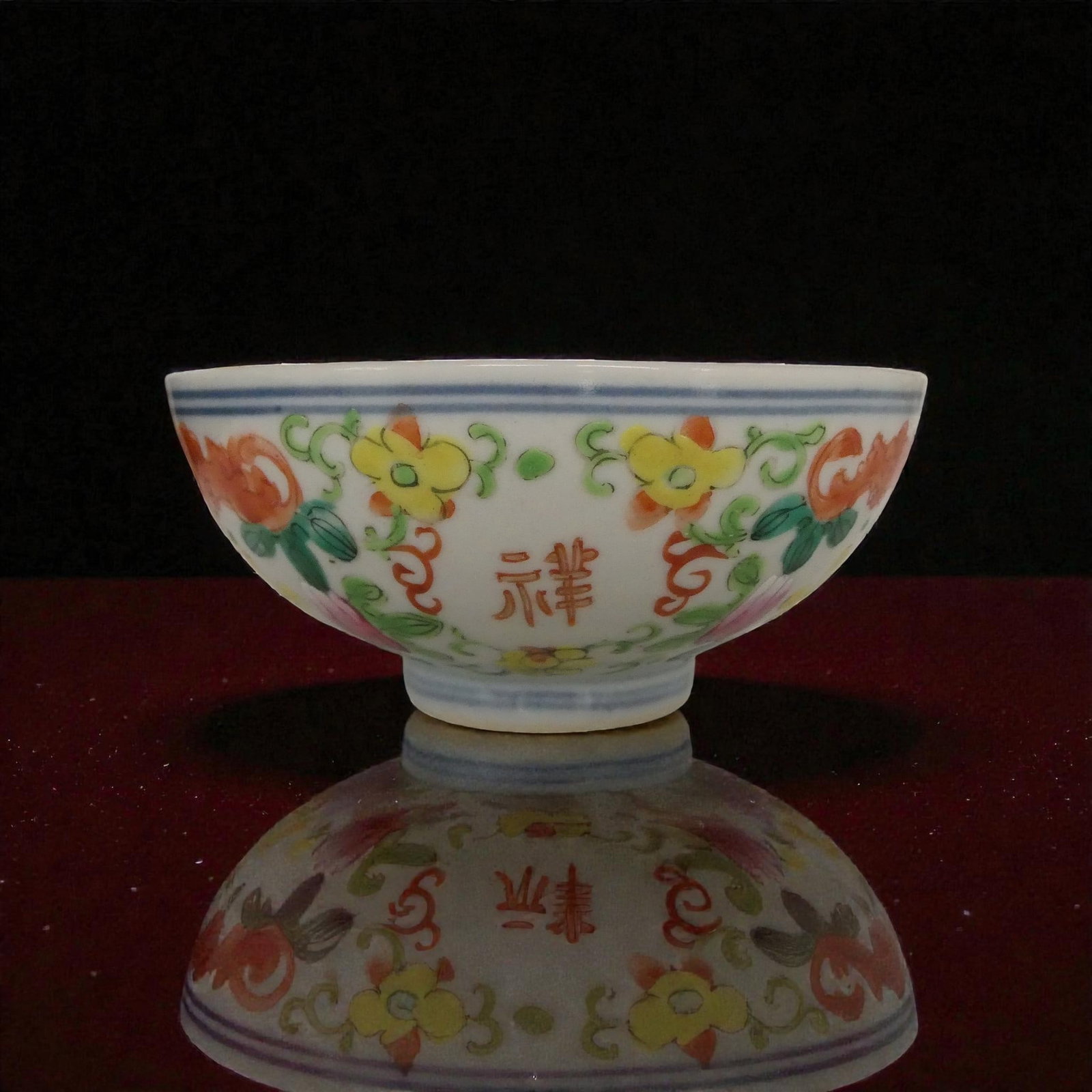 Chinese porcelain bowl hand painted floral decoration qing dynasty: A finely hand painted porcelain bowl decorated with vibrant floral motifs in rich enamel colors, showing delicate brushwork and balanced composition all around the exterior, with a small floral spray 