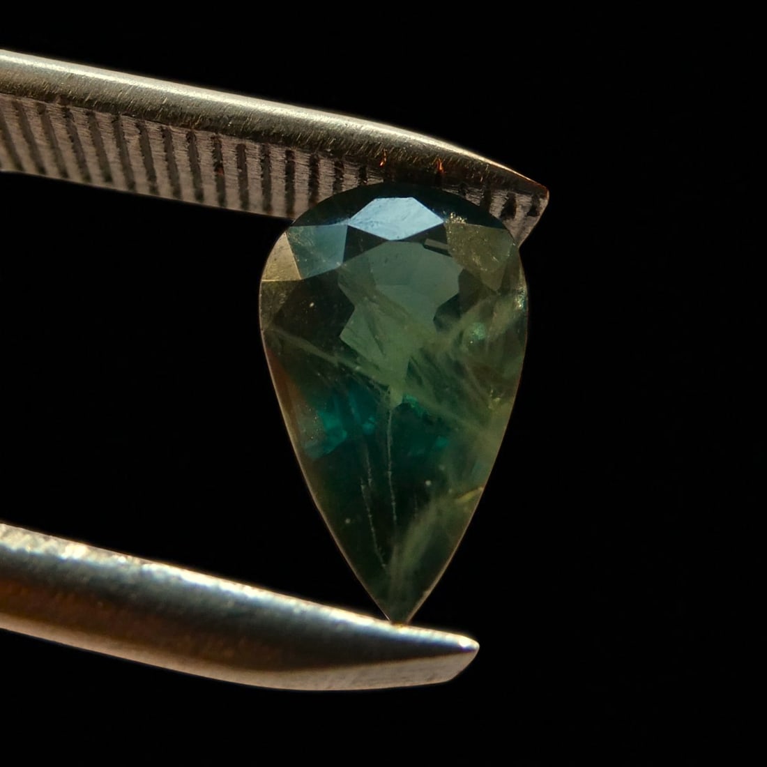 1.33 ct Pear-Cut Bi-Color Sapphire, ALGT Certified, Green-Blue: This rare and visually striking bi-color sapphire presents an intense interplay between deep forest green and saturated blue, artfully faceted into a classic pear mixed cut that enhances both the opti