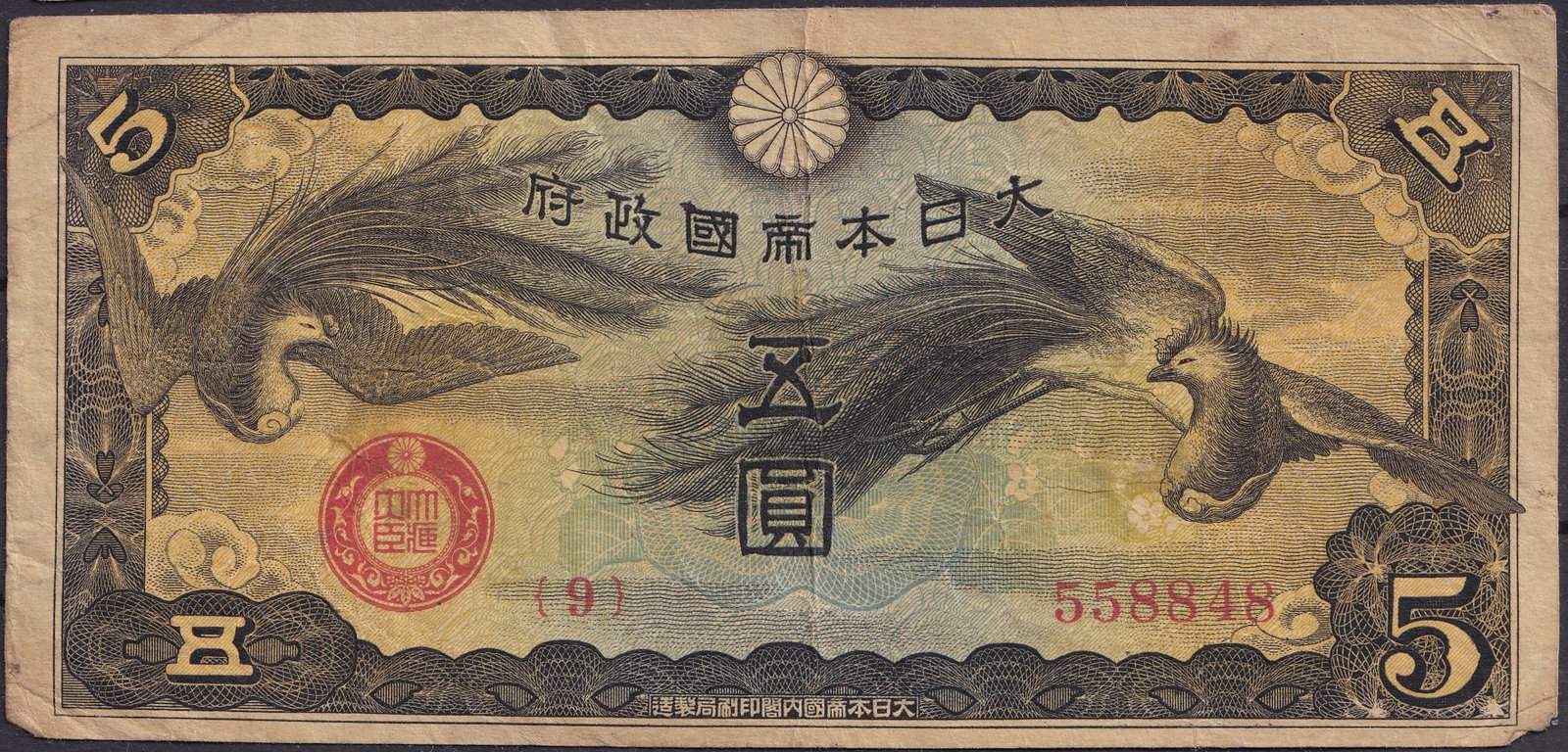 Japan 1943 5 Yen Phoenix Banknote, Showa Era, Red Seal, Serial 558848: Issued in 1943 during the Showa era under the Empire of Japan, this 5 Yen banknote represents one of the most symbolic wartime currency issues. The obverse depicts two phoenixes in flight, engraved wi