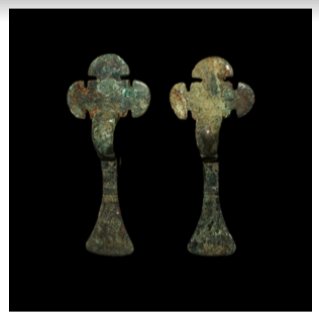 CRUCIFORM BOW BROOCH PAIR 5TH-6TH CENTURY A.D.: 3 1/2 in. (55 grams total, 90 mm each) DESCRIPTION: A pair of cruciform bow brooches, each composed of a square headplate decorated with stamped annulets, three semi-circular arms, bow and expanding f