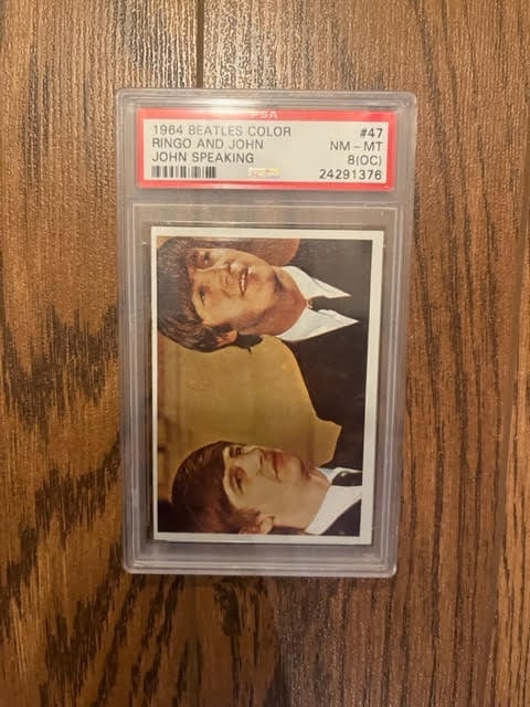 The Beatles 1964 Color Card #47 Ringo And John - John Speaking PSA NM-MT: This lot is a 1964 Beatles Color Card, PSA - NM-MT. The card features Ringo Starr and John Lennon of The Beatles. The Beatles were an English rock band, formed in Liverpool in 1960, that comprised Joh