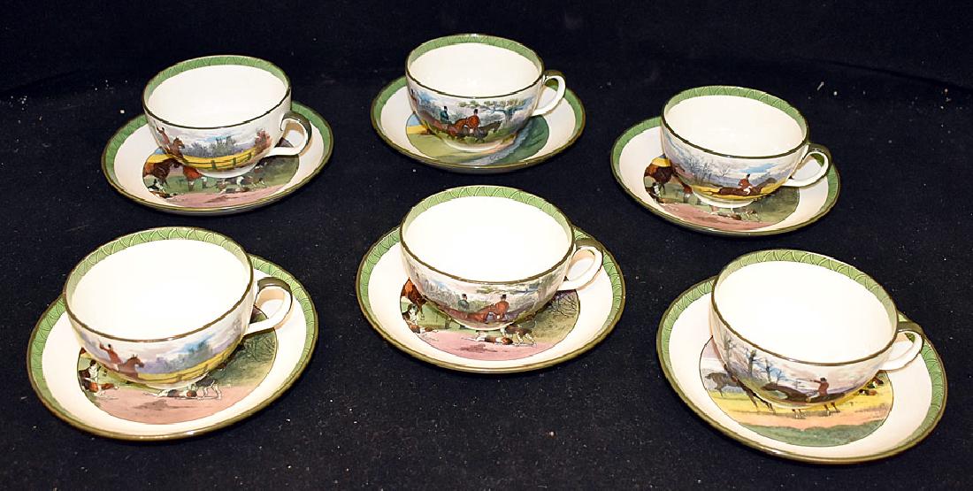 Six Mintons Hunt Scene Porcelain Cups and Saucers: A set of six Mintons porcelain hunt scene cups and saucers, each with a green geometric border. Marked. Saucers: 6 in diameter. Cups: 2 in tall x 3-1/2 in diameter. Provenance: From the Estate of Robe