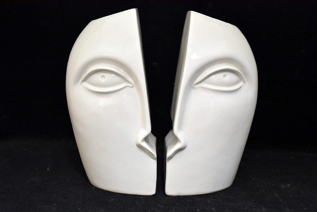 Pair of Raymor Pottery Face Bookends: A pair of unusual Raymor white-glazed pottery face vase bookends, model 2051. Marked "Mancer", "Made in Italy", "Raymor", and "Edelman" on base. Each: 10 in tall x 5-3/4 in wide x 4 in deep.