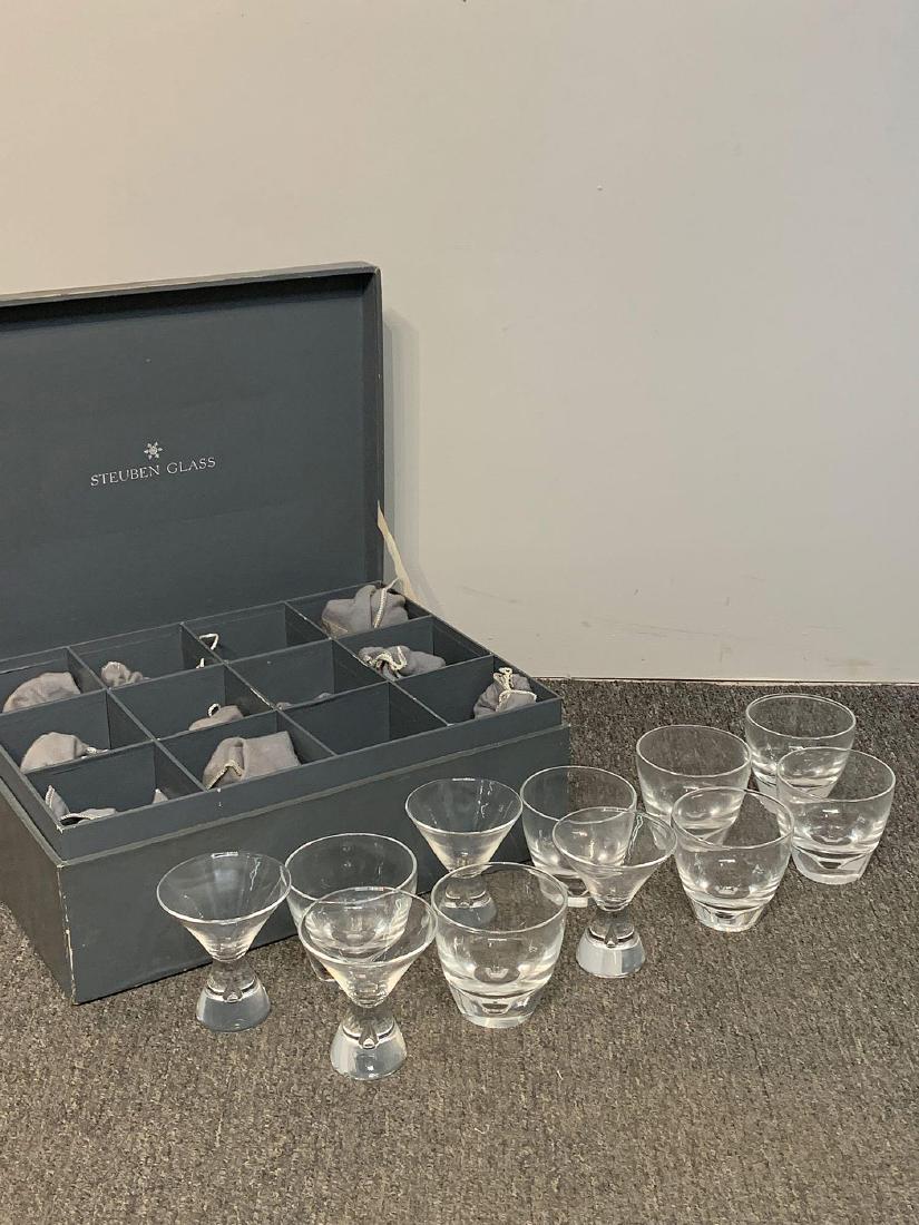 11 Steuben Cocktail Glasses with Case: A set of 11 Steuben cocktail glasses to include 7 rocks glasses and 4 "teardrop" martini glasses with a fitted cardboard case from Gump's, San Francisco. Martini glasses: 4in x 3-1/2in diameter.