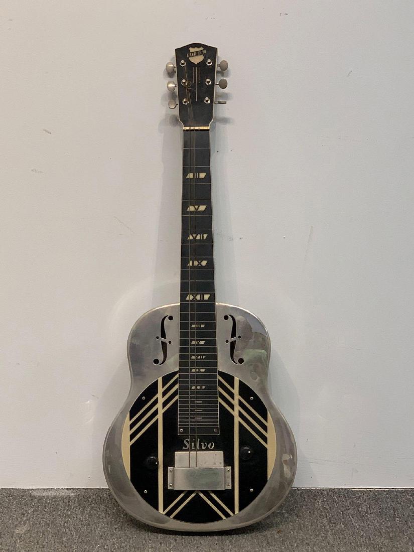 National Silvo Lap Steel Guitar: A National Silvo electric lap steel guitar. This model was introduced in 1937 and discontinued in 1942. With cut F holes, Bakelite coverplate with etched design, and Wwith case. Guitar: 32-1/2in long.