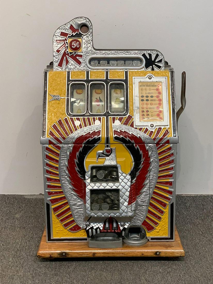 Mills War Eagle 5c Slot Machine: A 5-cent Mills Novelty Co. War Eagle slot machine. Classic three reel machine with a central image of an eagle in yellow, red, and black. 26 in tall x 16 in wide x 15-1/2 in deep.