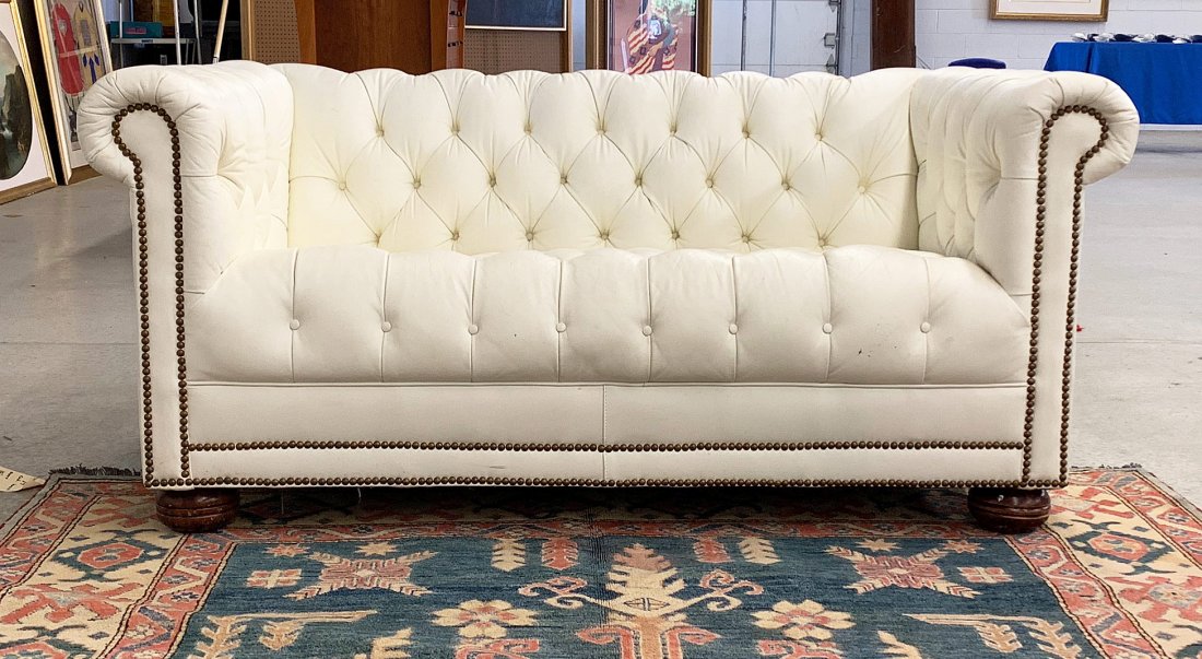 White Leather Chesterfield Loveseat: A tufted white leather chesterfield loveseat by Emerson Leather, Hickory N.C., on turned legs. 28 in tall x 60 in wide x 32 in deep.