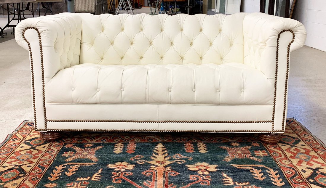 White Leather Chesterfield Loveseat: A tufted white leather chesterfield loveseat by Emerson Leather, Hickory N.C., on turned legs. 28 in tall x 60 in wide x 32 in deep.