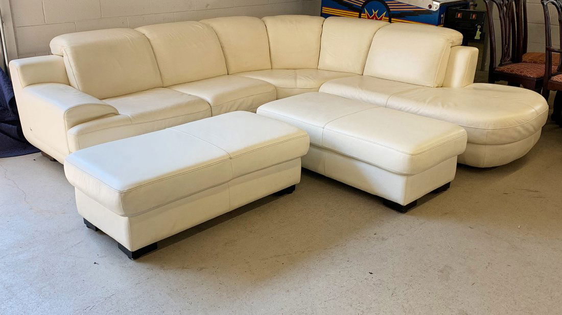 Italian White Leather Sectional Sofa: An Italian white leather sectional sofa in three parts with two ottomans. "Made in Italy" on bottom and marked with a metal stylized "H" tag.