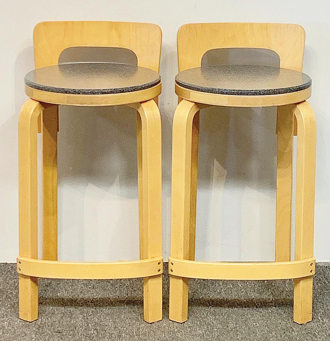 Two Alvar Aalto K65 Barstools: Two Alvar Aalto K65 birch barstools with custom added Corian seats. 28in tall x 15in wide x 14in deep. Provenance: The Adelman Estate Collection, Hockessin DE.