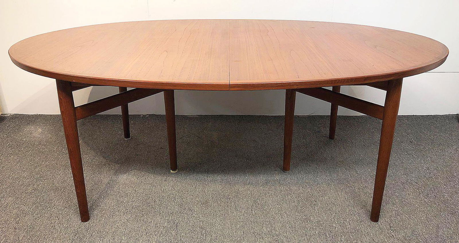 Arne Vodder Sibast Teak Dining Table: An Arne Vodder teak extension dining table for Sibast Furniture, Model 212. With an oval top with cross-banded edge, resting on six tapering legs. Provenance: The Adelman Estate Collection, Hockessin