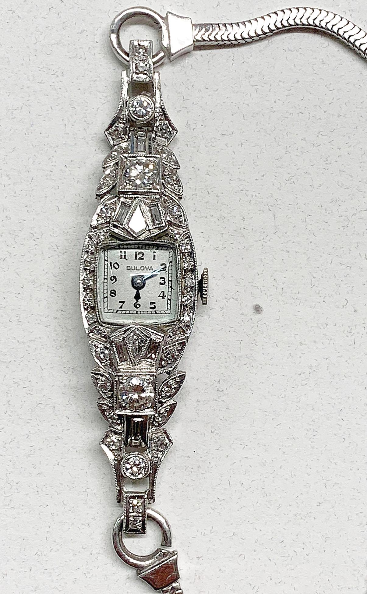 Ladies 14K, Platinum, and Diamond Bulova Watch: A vintage ladies 14K white gold, platinum, and diamond Bulova bracelet watch with square white dial, two round brilliant cut diamonds (0.5ct total, G/H color, VS clarity), 16 single cut diamonds (0.16