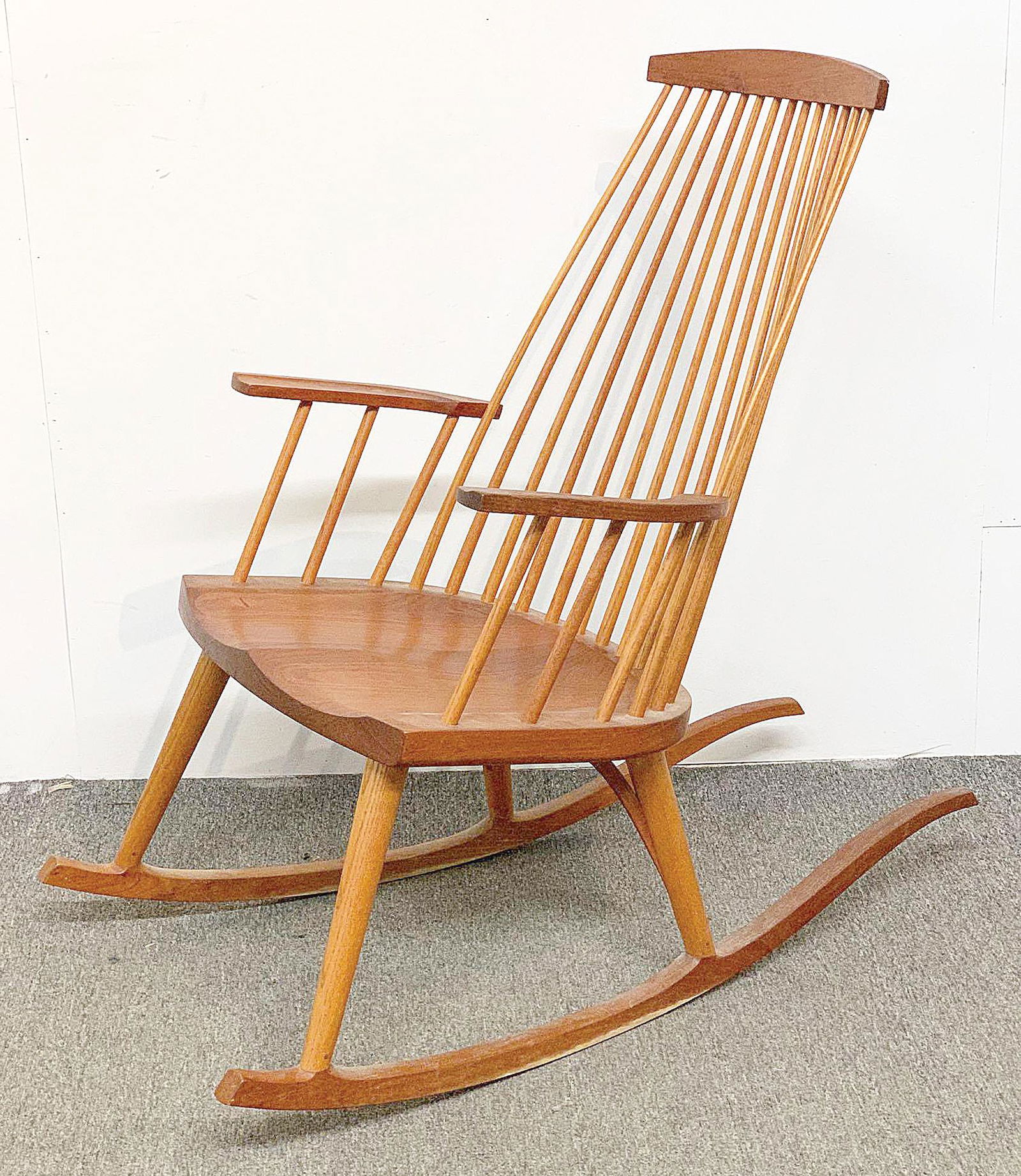 Thomas Moser Rocking Chair: A Thomas Moser Cabinetmakers (Auburn, Maine) rocking chair, in cherry and ash. Hand signed and dated 1987 on base. 38-1/2in tall x 23in wide x 39in deep.
