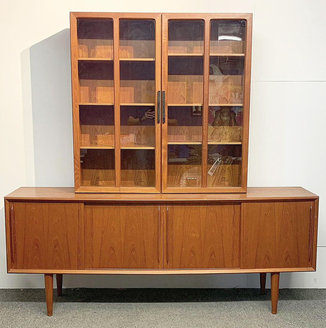 Danish Modern Teak Credenza and Cabinet: A grouping to include a Danish modern teak credenza/sideboard with a bowed front and four sliding doors, one side fitted with drawers, raised on four tapering legs, made by H.P. Hansen, and stamped Ma