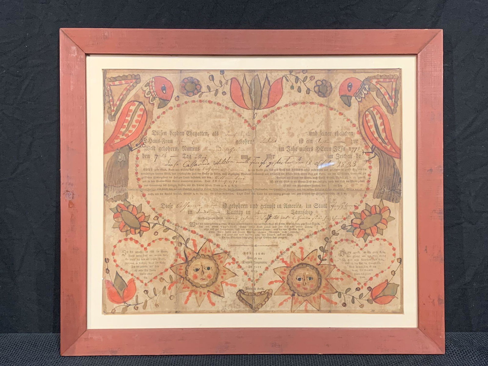 Gottlob Jungmann Printed & Colored Fraktur: A 1975 Lehigh County, Pennsylvania fraktur by Gottlob Jungmann, having a central heart flanked by birds, foliate design, and two suns. Framed under glass. Mat opening: 13in x 15-3/4in. Outside frame: 