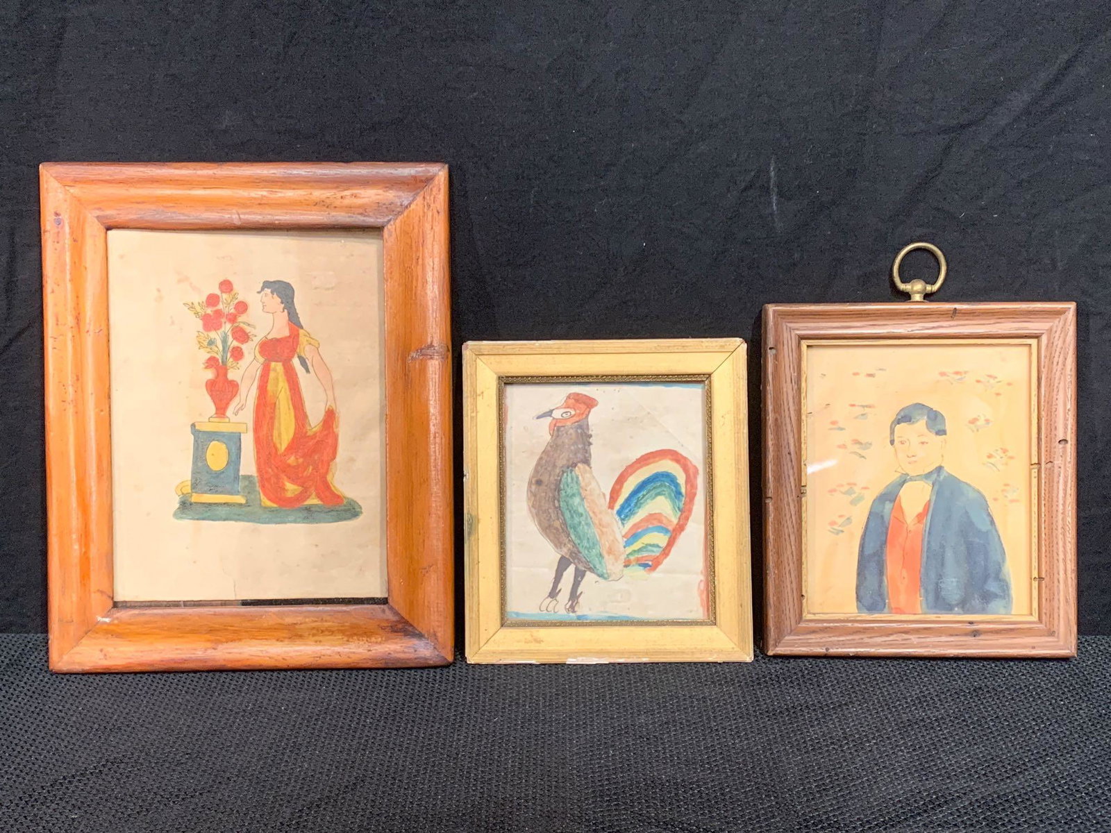Three Ink & Watercolor Fraktur Drawings: A grouping of three 19th C. ink and watercolor fraktur drawings to include a portrait of a man, a rooster, and a woman with floral urn. All framed under glass. Largest frame opening: 7-1/2in x 5-1/2in