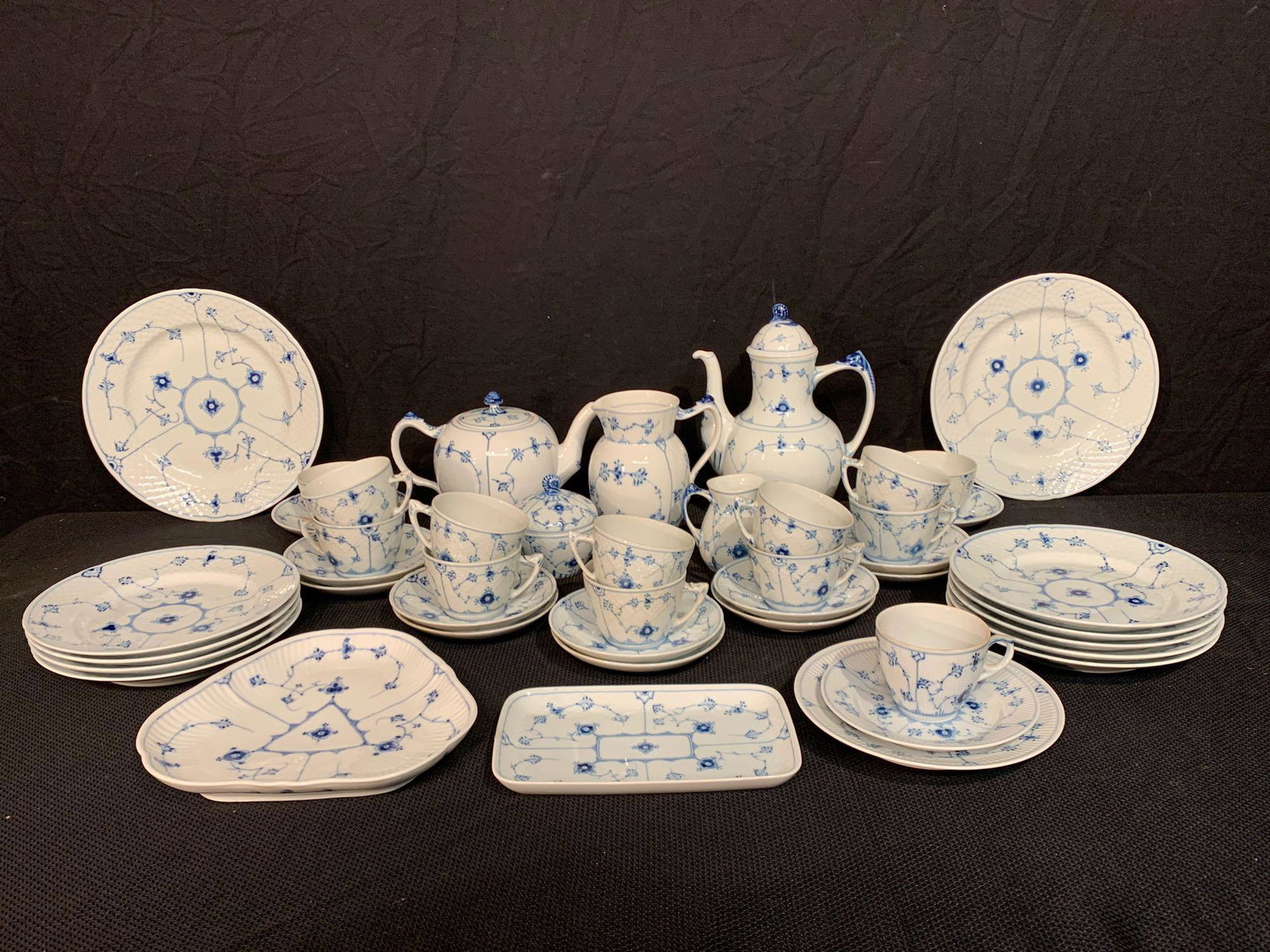 45-pcs. Danish Blue Fluted China: A 45-piece service of B&G and Royal Copenhagen china in the "Blue Fluted" pattern to include a coffee and tea set; additional pitcher; cups and saucers; and various service pieces and plates. All mark