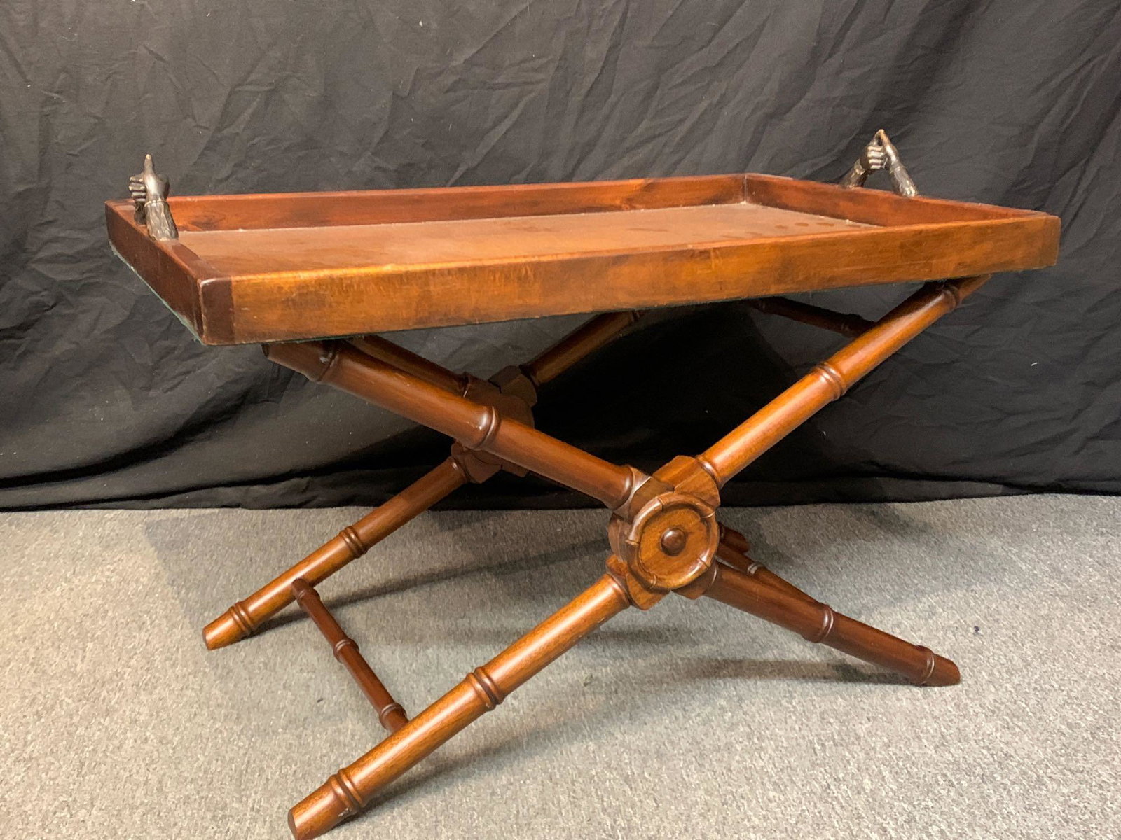 Theodore Alexander Library Tray on Stand: A Victorian-style tray on stand by Theodore Alexander, with the tray having a tooled leather surface and hand-form handles, resting on a folding faux-bamboo stand. Can be used as coffee table or serve