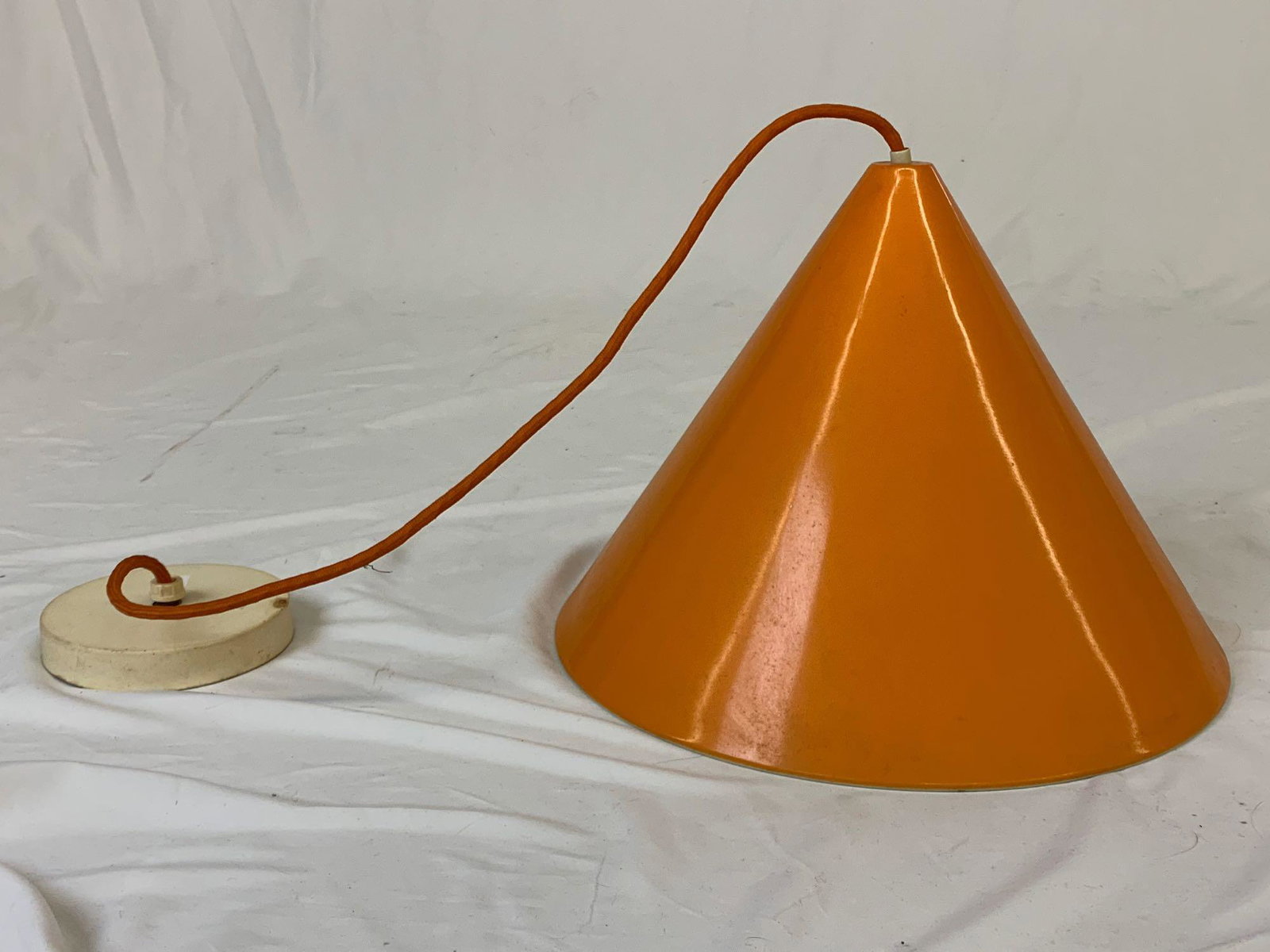 Modernist Hanging Pendant Light: A midcentury modern Orange enameled pendant light. Unmarked. Shade: 10in tall x 13-3/4in diameter. Hangs 34-1/2in from ceiling.