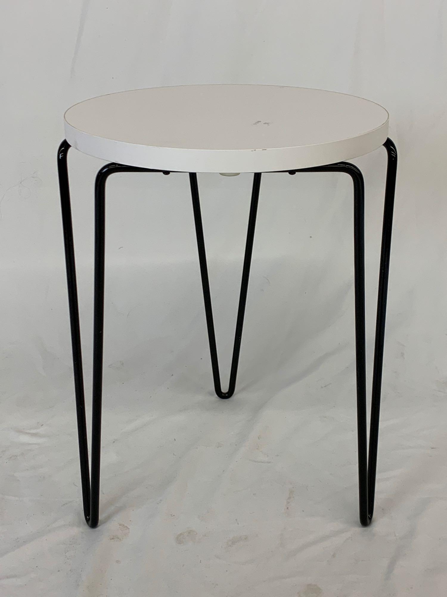 Contemporary Florence Knoll Hairpin Stool: A Florence Knoll for Knoll Studio hairpin stool or side table with white laminated top and black enameled hairpin legs. Metal tag. Can stack with previous lot. 18in tall x 13in diameter.