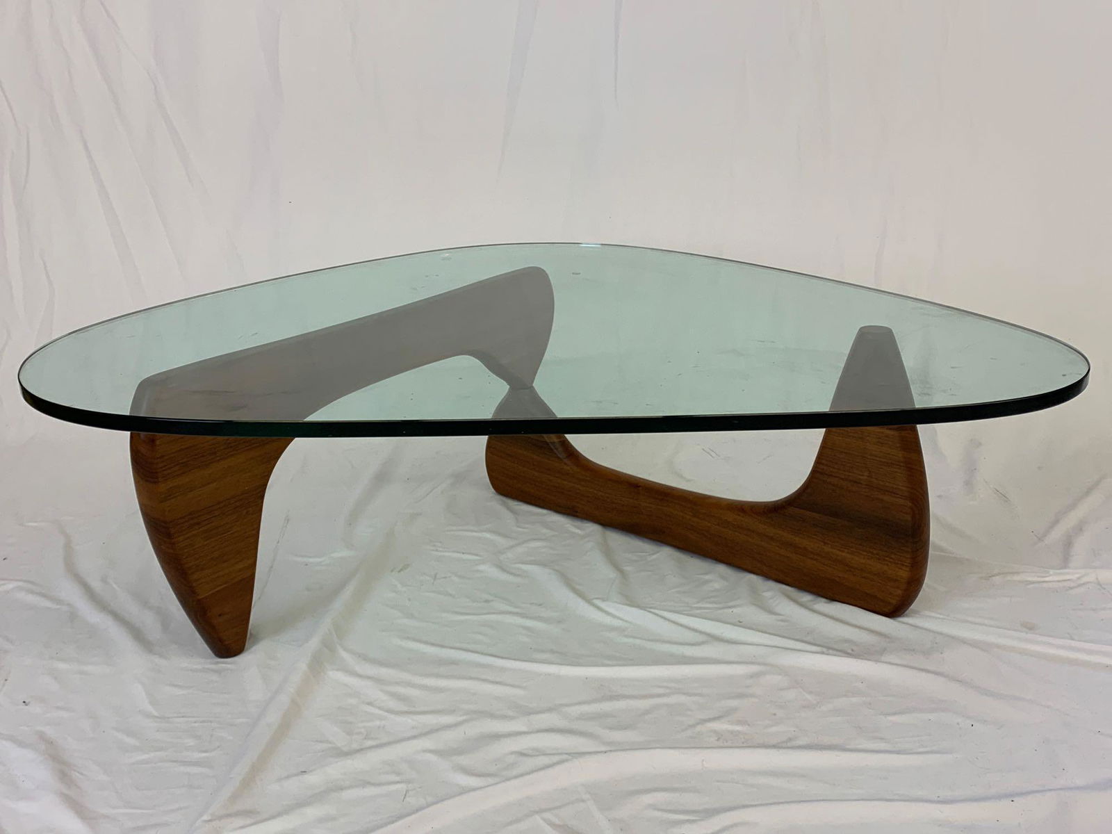 Isamu Noguchi/Herman Miller Coffee Table: An Isamu Noguchi for Herman Miller model IN-50 coffee table with walnut base and shaped glass top. Unmarked but with original receipt. 15-3/4in tall x 50in wide x 36in deep.