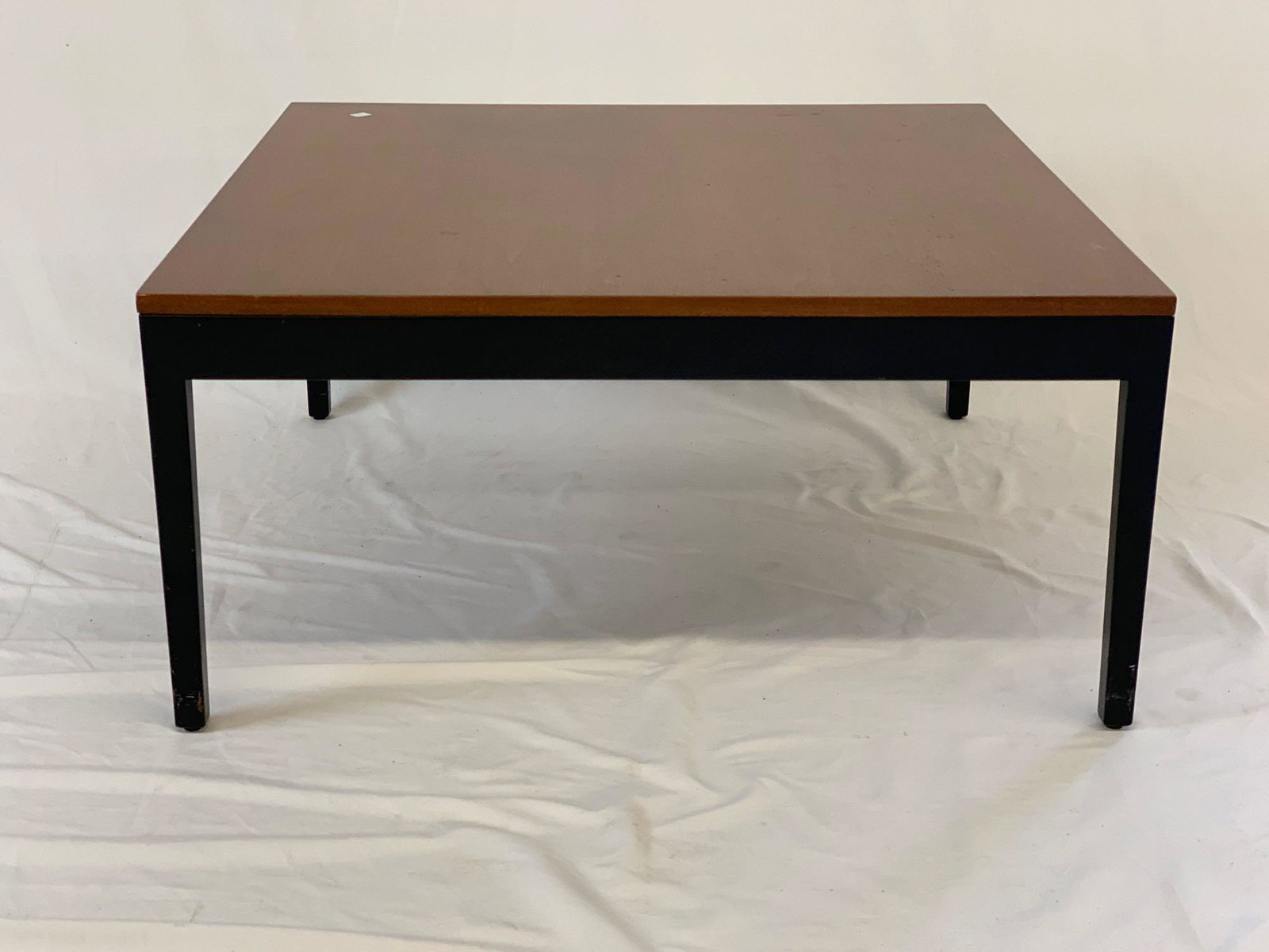 George Nelson/Herman Miller Coffee Table: A George Nelson for Herman Miller coffee table with square walnut top over an ebonized base with tapering legs. Circular medallion label. 15in tall x 32in wide x 32in deep.