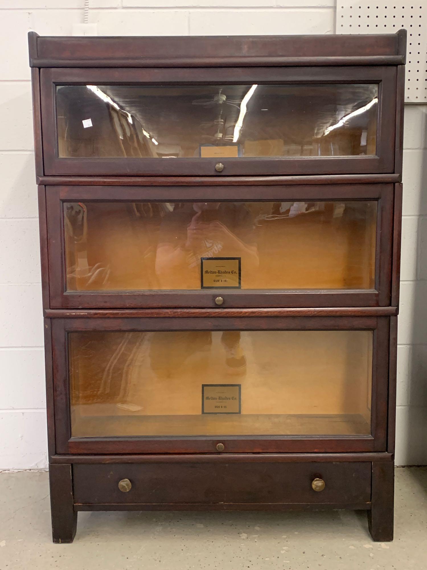 Melton-Rhodes Mahogany Sectional Bookcase: A Melton-Rhodes mahogany sectional barrister bookcase having three stacking compartments (12-1/4, 10-1/4, and 8-1/4in) on a drawered base. 49in tall x 34in wide x 11in deep.
