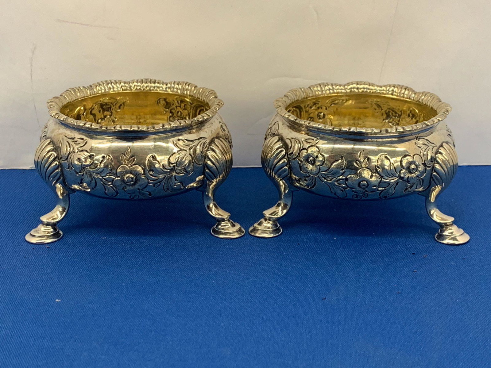 Pair of Georgian Sterling Silver Salt Cellars: A pair of Georgian sterling silver salt cellars with chased foliate design and trifid base. Hallmarks on base for maker "t". 1-7/8 x 3-1/4in. Approx 6.3ozt.