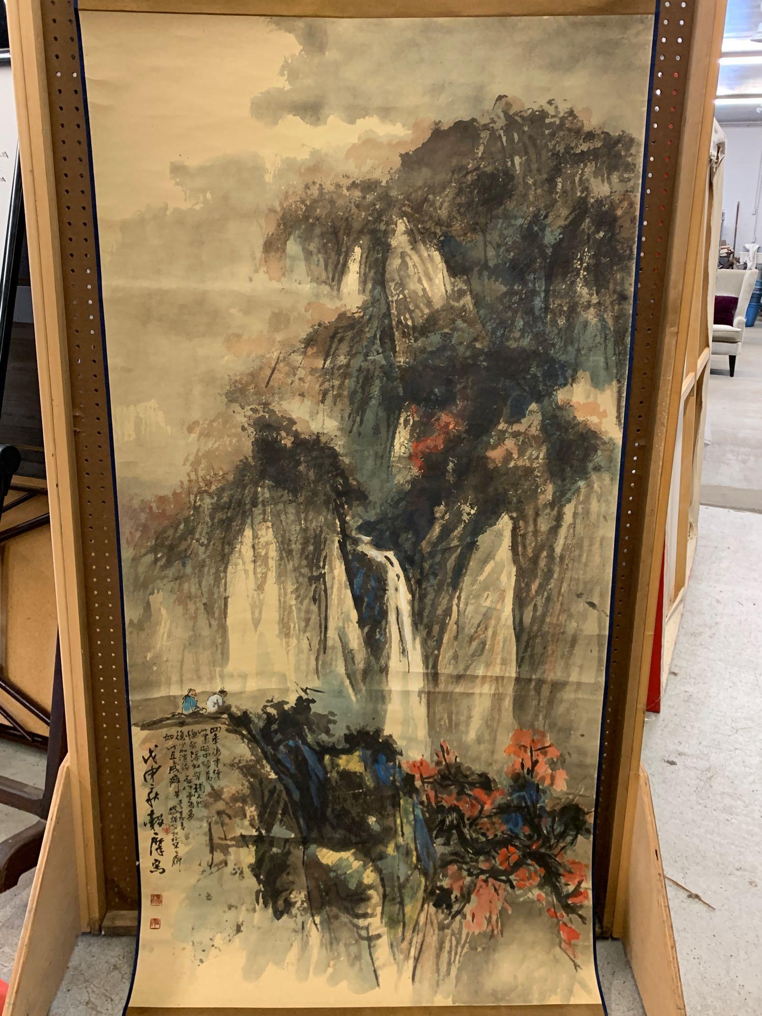 Chinese Scroll Painting: A Chinese scroll painting depicting a mountainous landscape with two figures, and having calligraphy markings and red seals. Image: 70in x 35in.