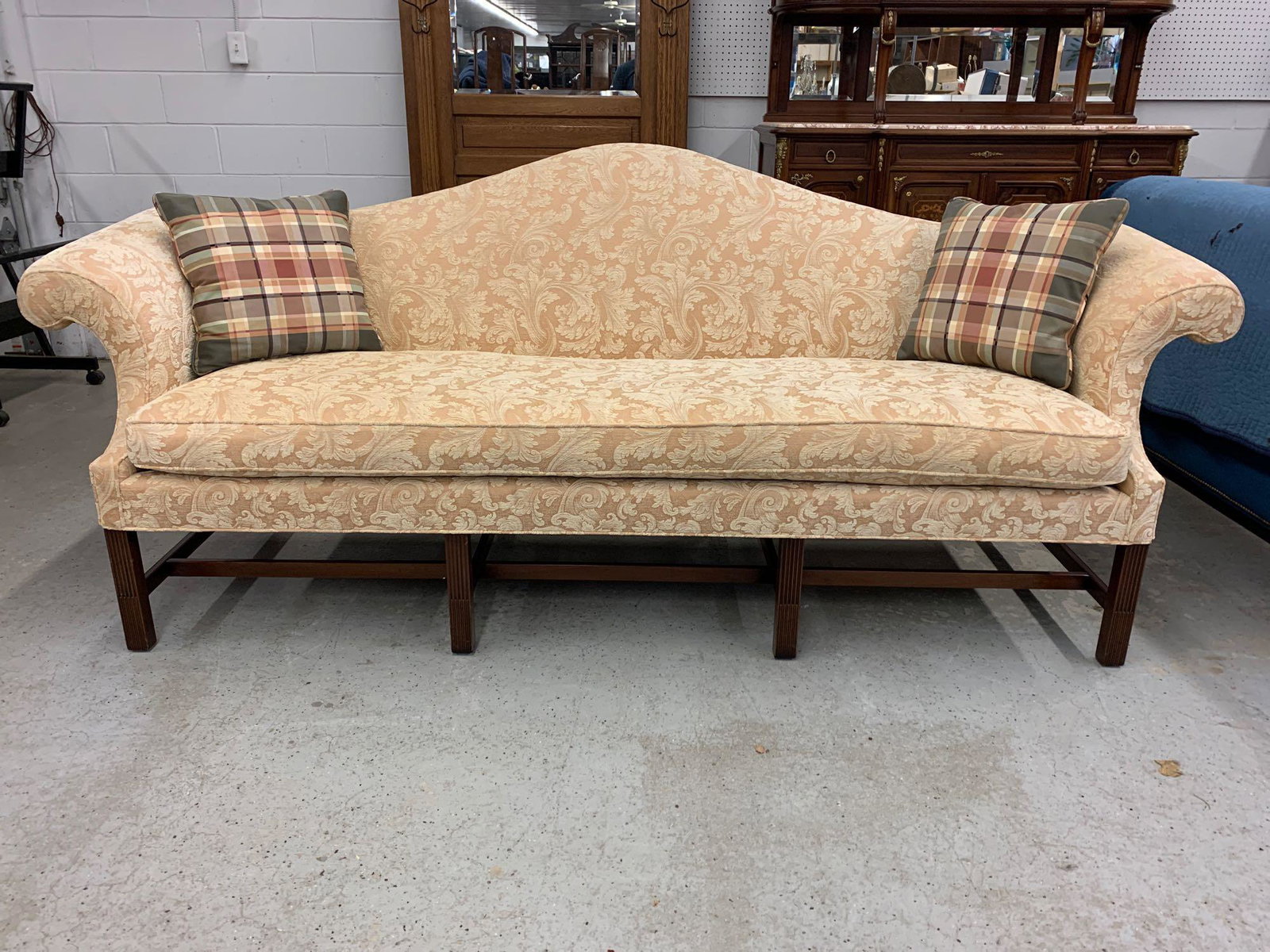 Kittinger Newport Reproduction Mahogany Sofa: A Kittinger Historic Newport Reproduction Chippendale-style camelback sofa with scrolled arms and mahogany stretcher frame. Branded mark. 39in tall x 96in wide x 32in deep.