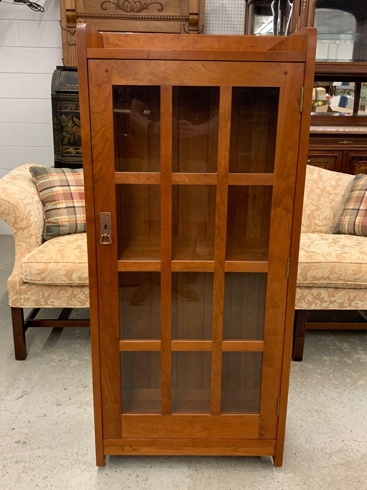 Contemporary Stickley Cherry Bookcase: A contemporary Stickley Arts & Crafts cherry bookcase, having a single glass paned door and three shelves. Branded mark. 56in tall x 25in wide x 12in deep.
