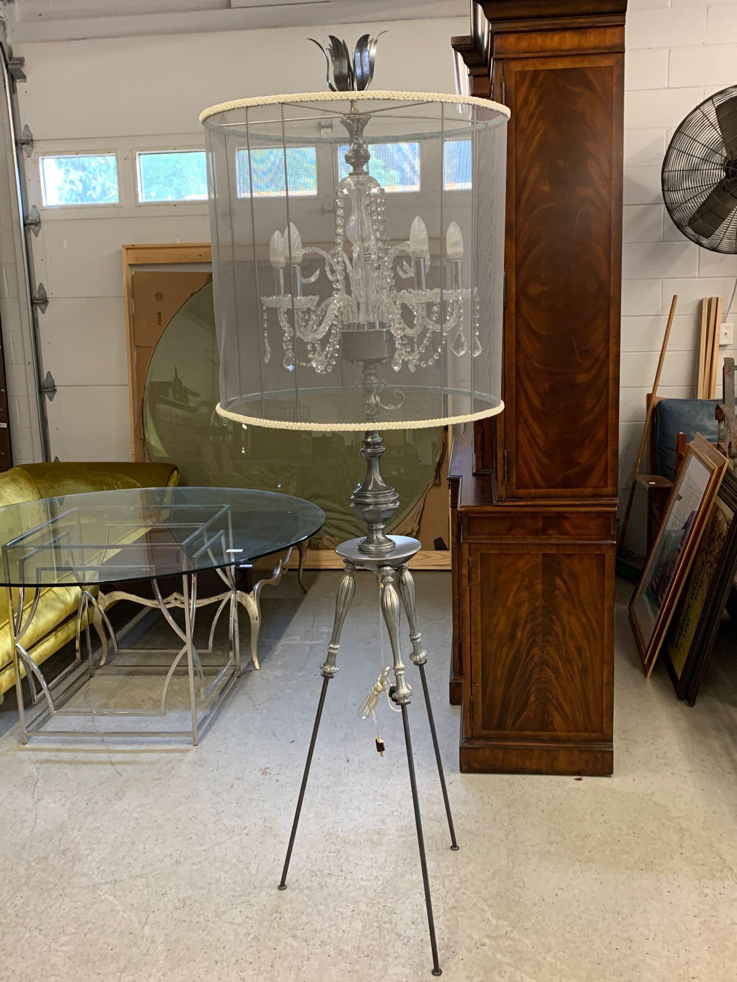 Contemporary Floor-standing Chandelier: A contemporary decorator floor-standing chandelier comprised of a five-arm glass fixture with swag and crystal drops surrounded by a mesh drum shade and supported by a cast metal tripod base. Unmarked