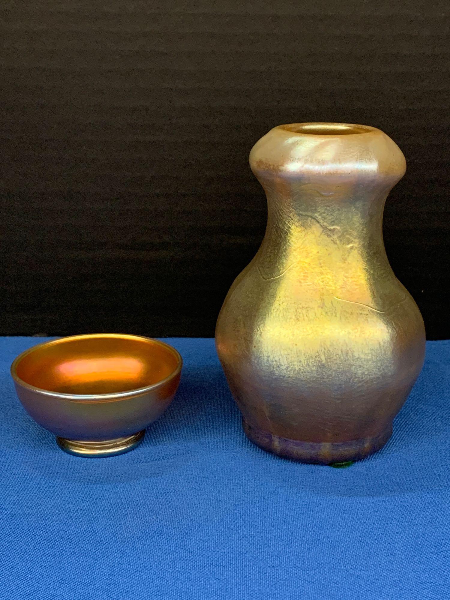 Tiffany Favrile Glass Vase and Salt Cellar: A two-piece Louis Comfort Tiffany favrile glass grouping to include a small vase and a salt cellar, both with paper labels. Salt cellar signed LCT. Vase: 4-3/4in tall.